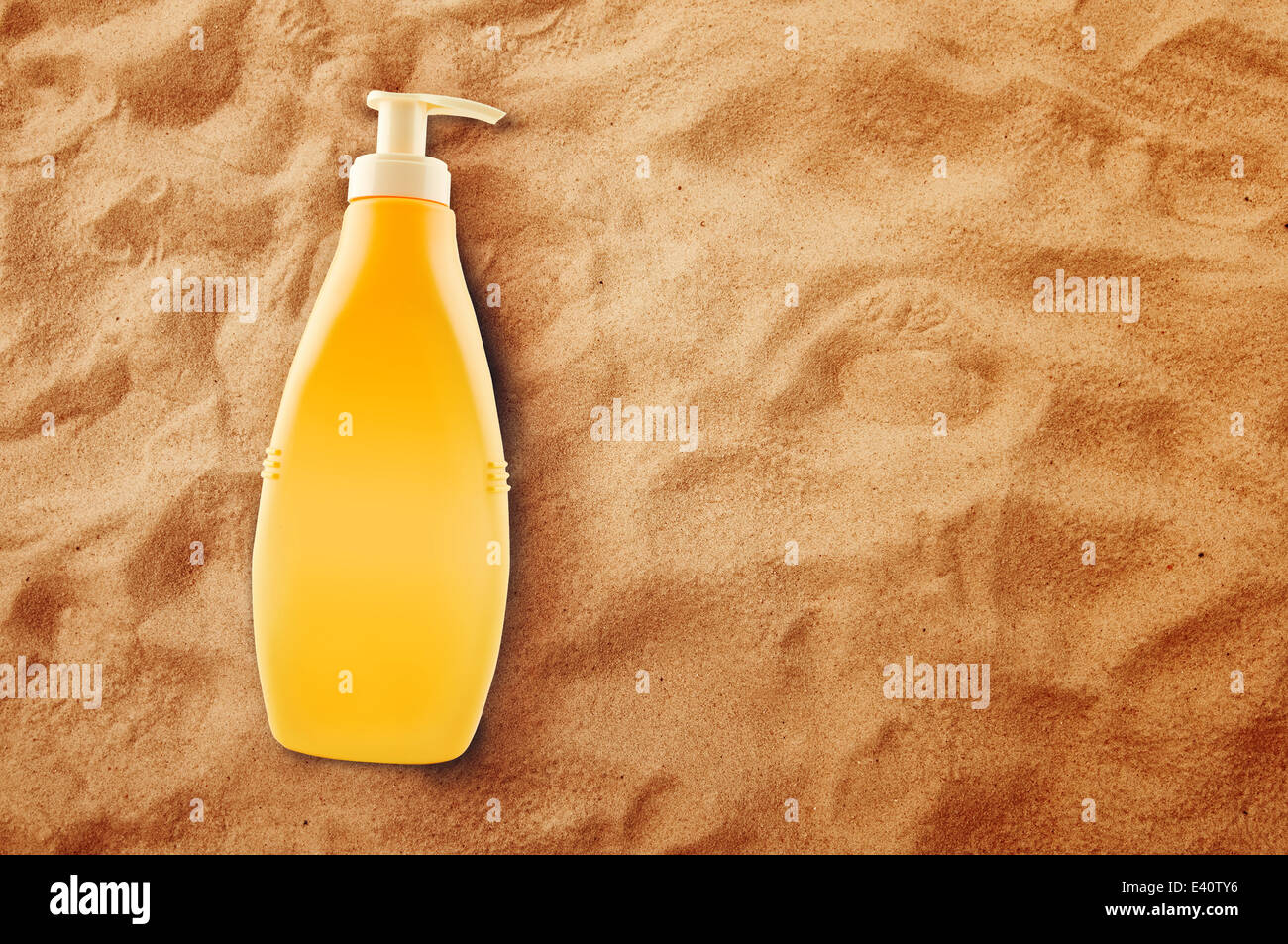 Bottiglia di olio di prendere il sole o la protezione solare caldo sulla spiaggia di sabbia in estate. Foto Stock