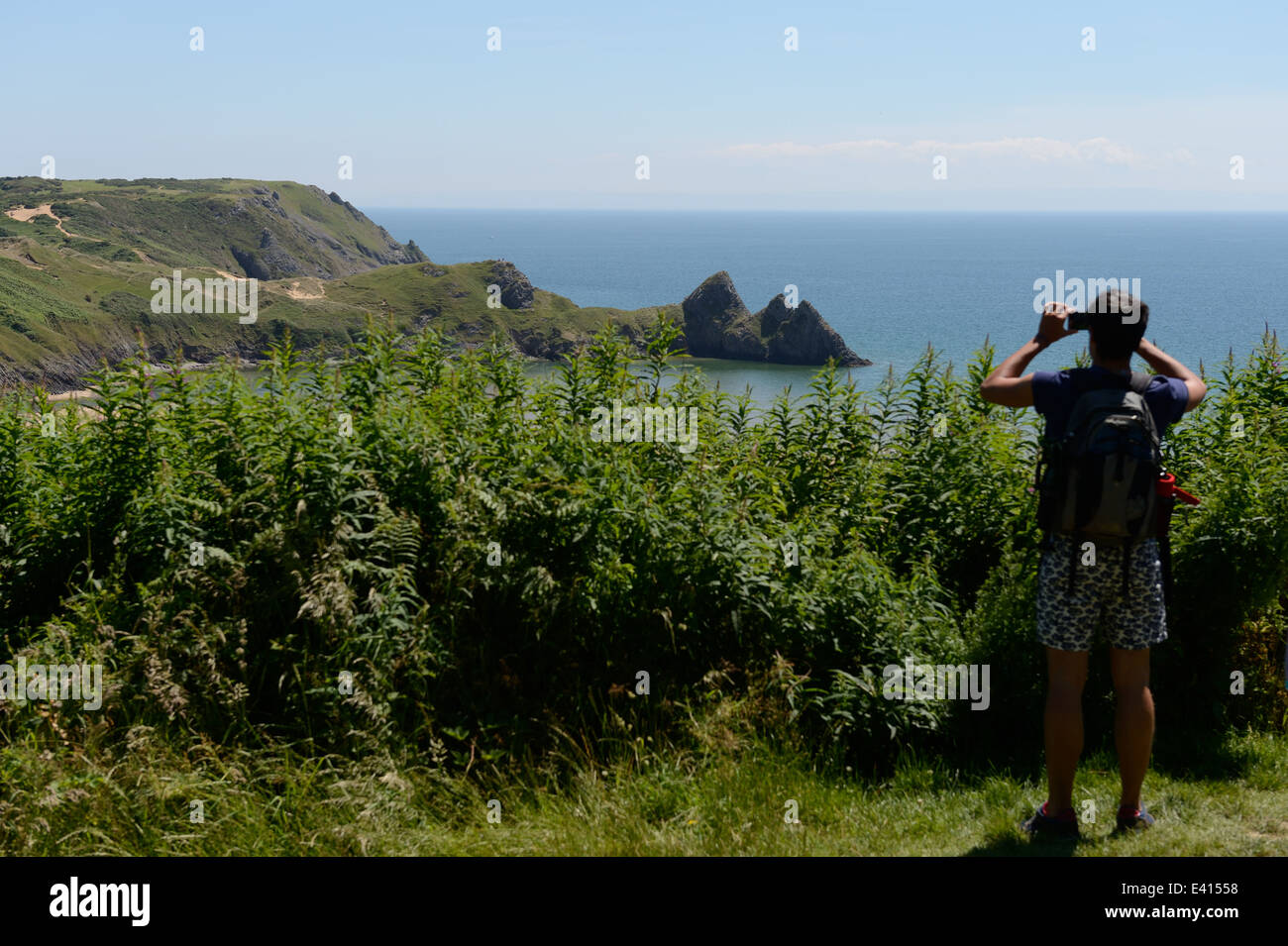 L'uomo scattare fotografie con la fotocamera del telefono di -Three Cliffs Bay,Gower Foto Stock