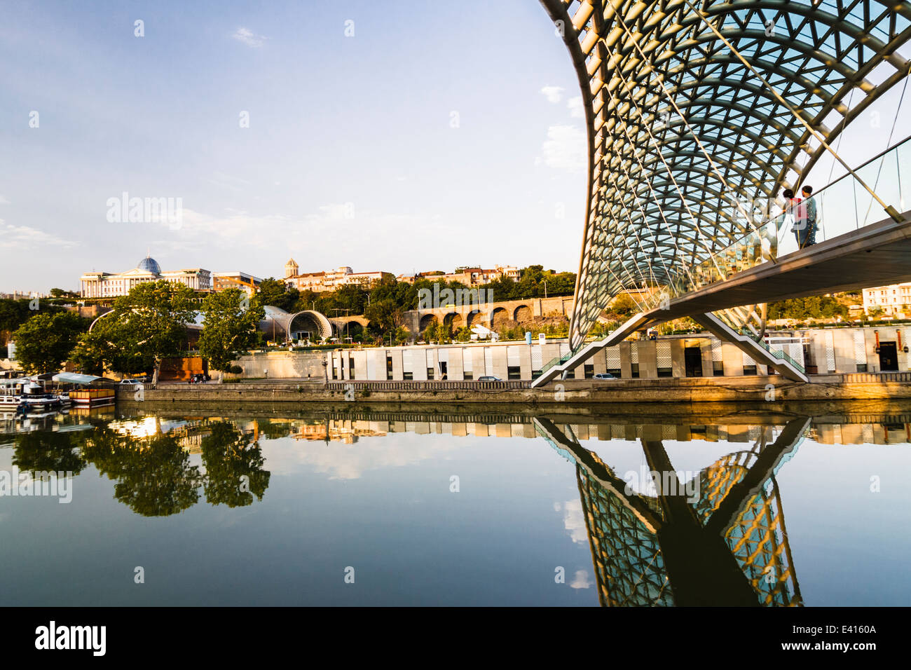 Ponte di Pace (Mshvidobis Khidi) oltre il fiume Mtkvari con Palazzo presidenziale in background. Tbilisi, Georgia Foto Stock