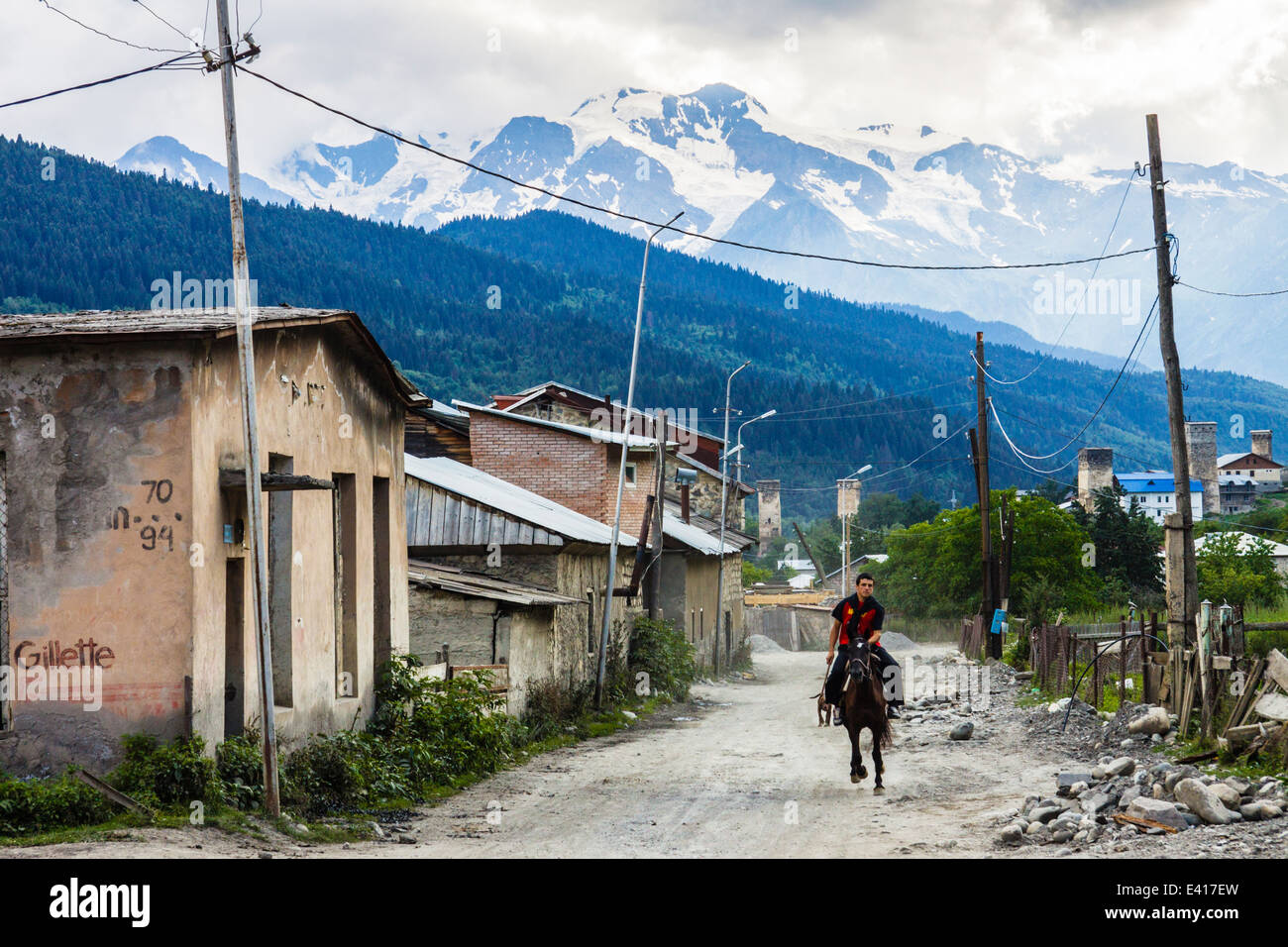Uomo georgiano in sella ad un cavallo contro un sfondo delle montagne in Mestia, Svaneti, Georgia Foto Stock