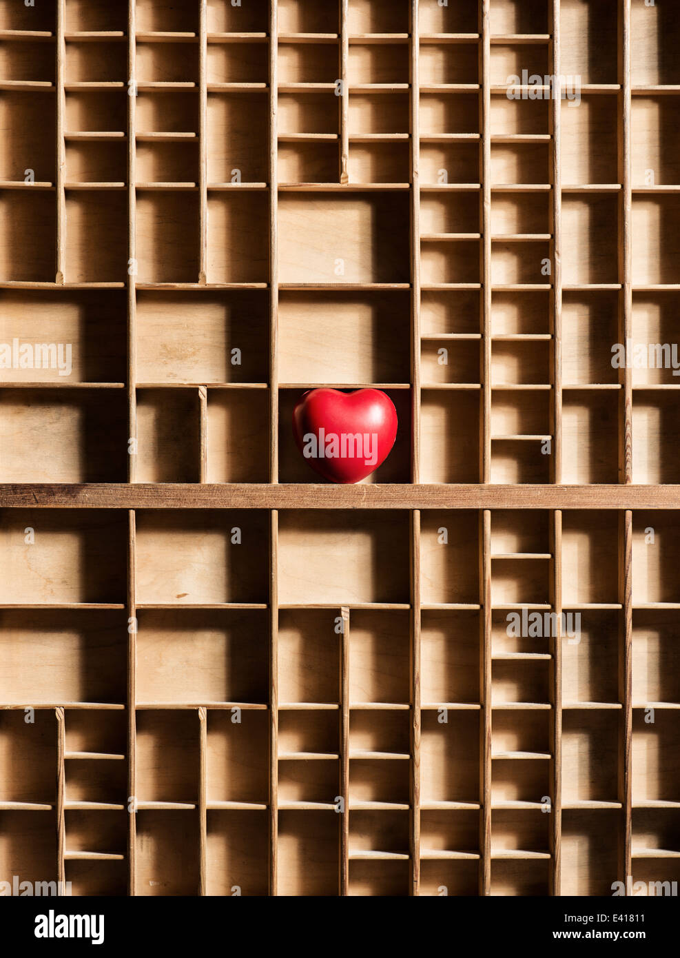 Cuore rosso vuoto nella scatola di legno con numerosi scomparti. Immagine concettuale di amore perduto e di solitudine e nascosto e romantica sentimenti. Foto Stock