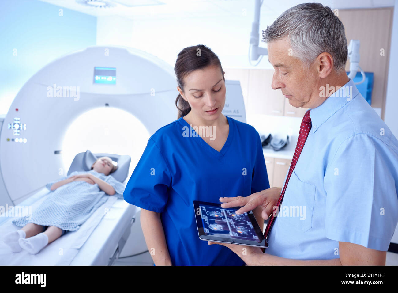 La ragazza di scanner CT, medico radiologo e guardando la scansione sulla tavoletta digitale Foto Stock