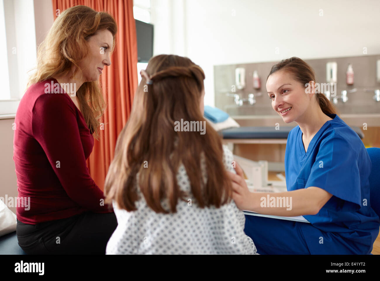 L'infermiera a parlare con il paziente e madre Foto Stock