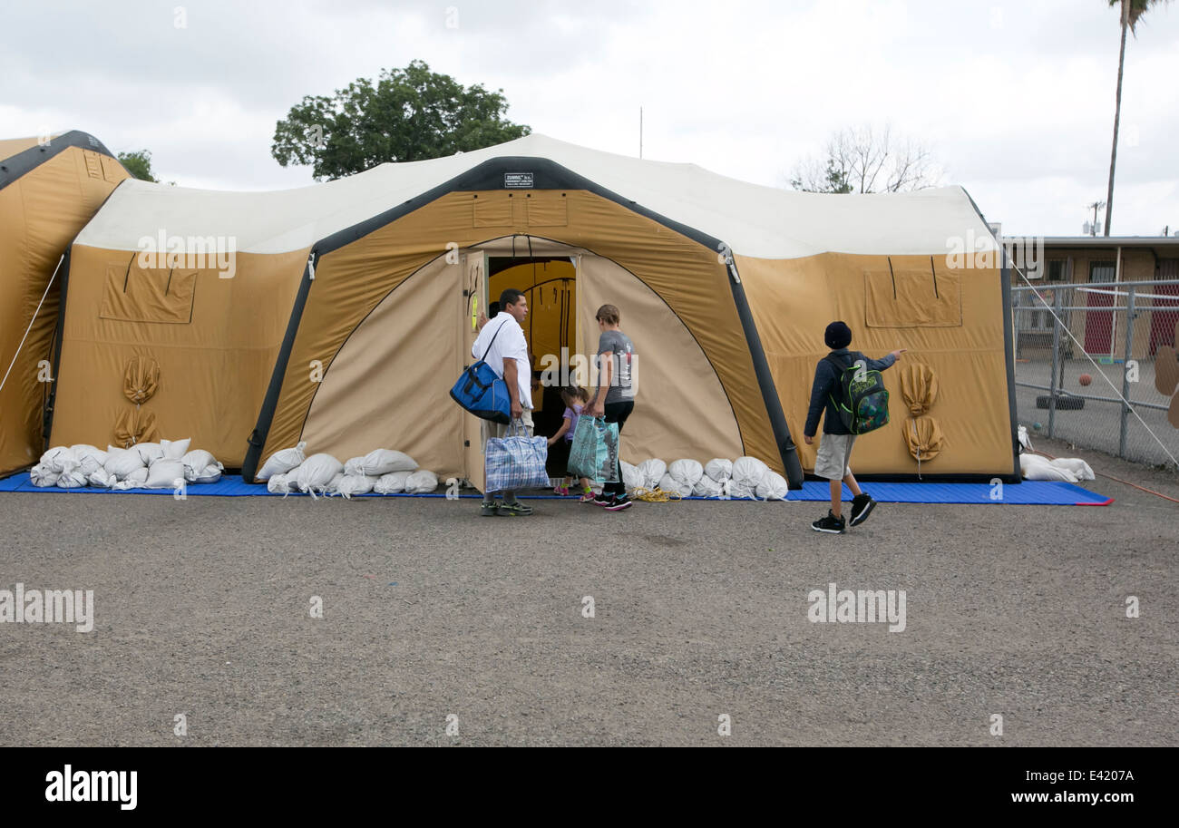 La famiglia entra nella tenda a fare-shift shelter in McAllen Texas dove ondata di immigrati provenienti da America centrale hanno attraversato la frontiera Foto Stock