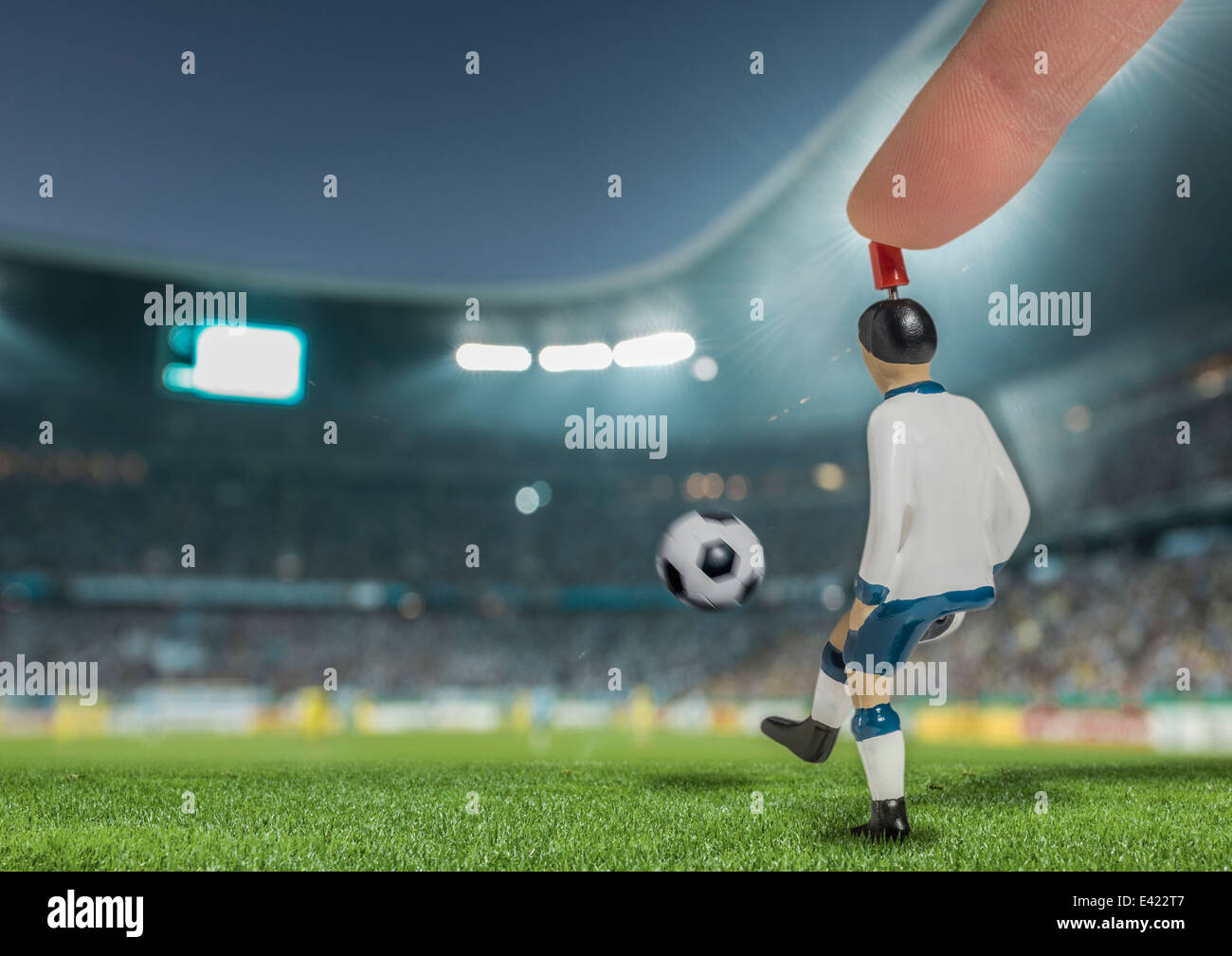 Generati digitalmente immagine del giocatore di calcio calci palla in stadio illuminati Foto Stock