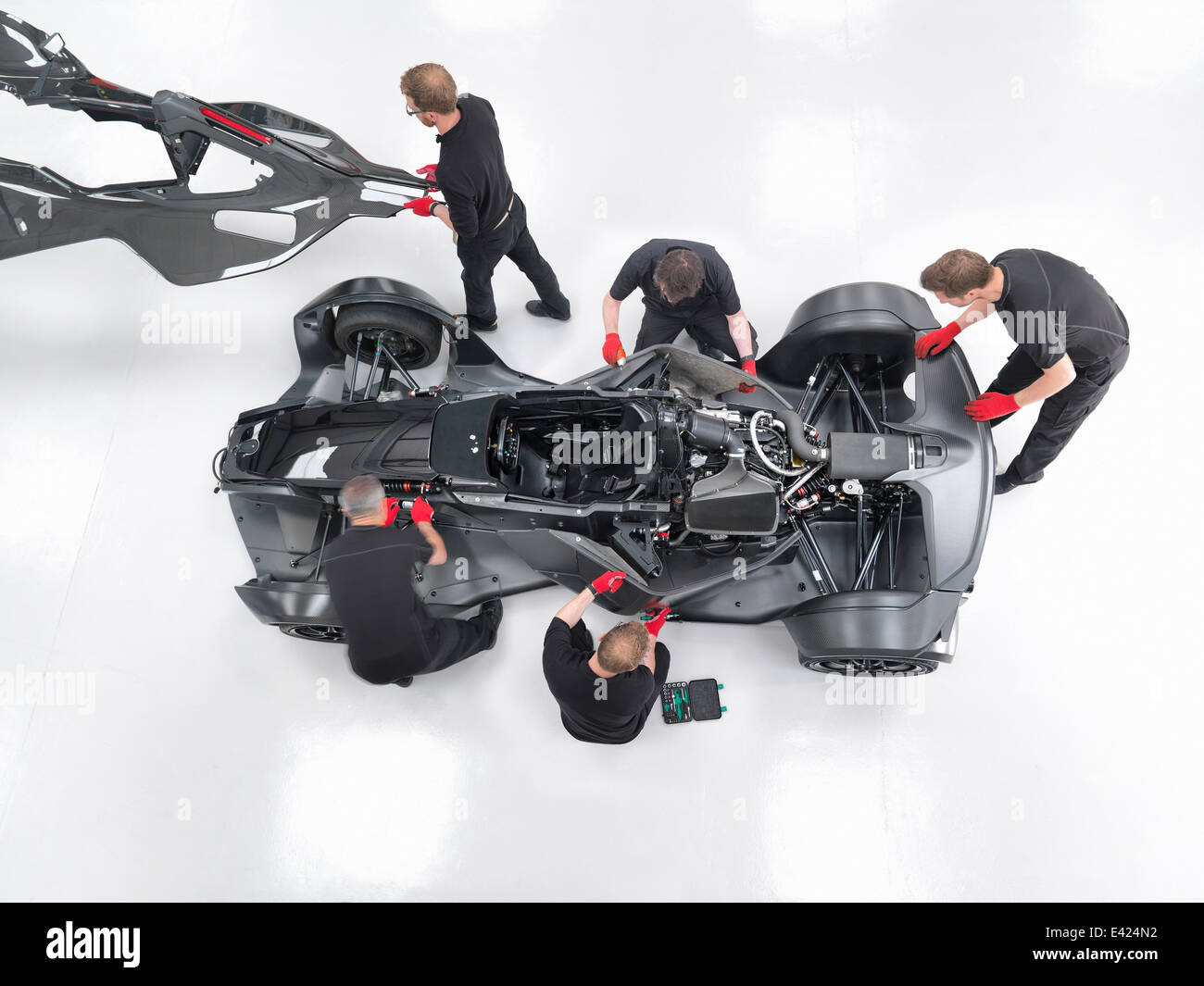 Ingegneri assemblare supercar in auto sportiva fabbrica, vista aerea Foto Stock