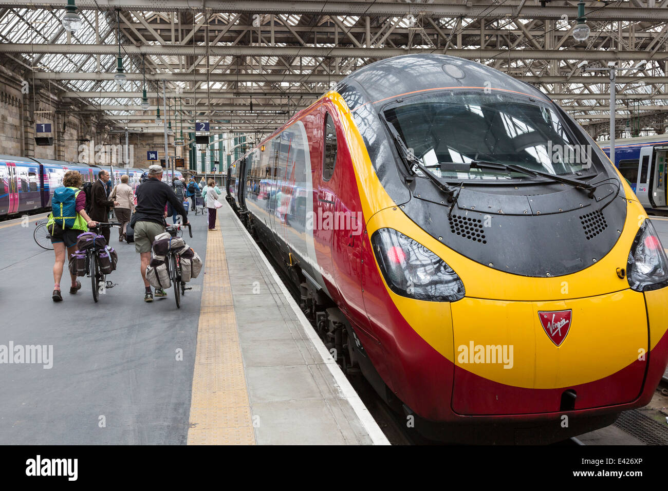Due ciclisti di salire a bordo di una Vergine con il treno alla stazione centrale di Glasgow, Glasgow, Scotland, Regno Unito Foto Stock
