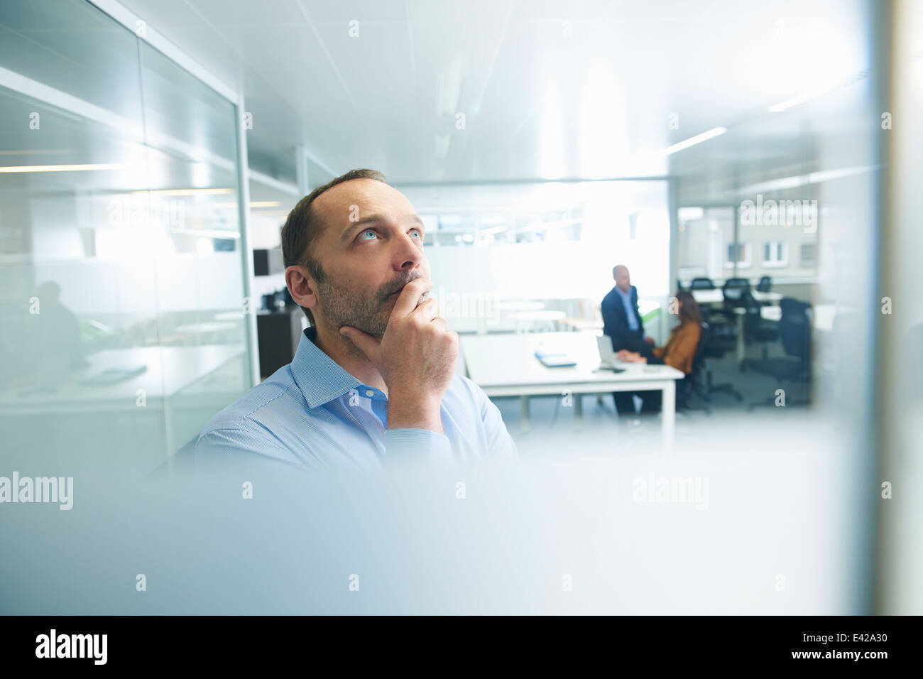 L'uomo pensa la gente in background Foto Stock