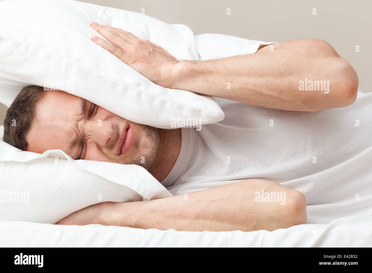 Ritratto di giovane insoddisfatto uomo caucasico nel letto Foto Stock