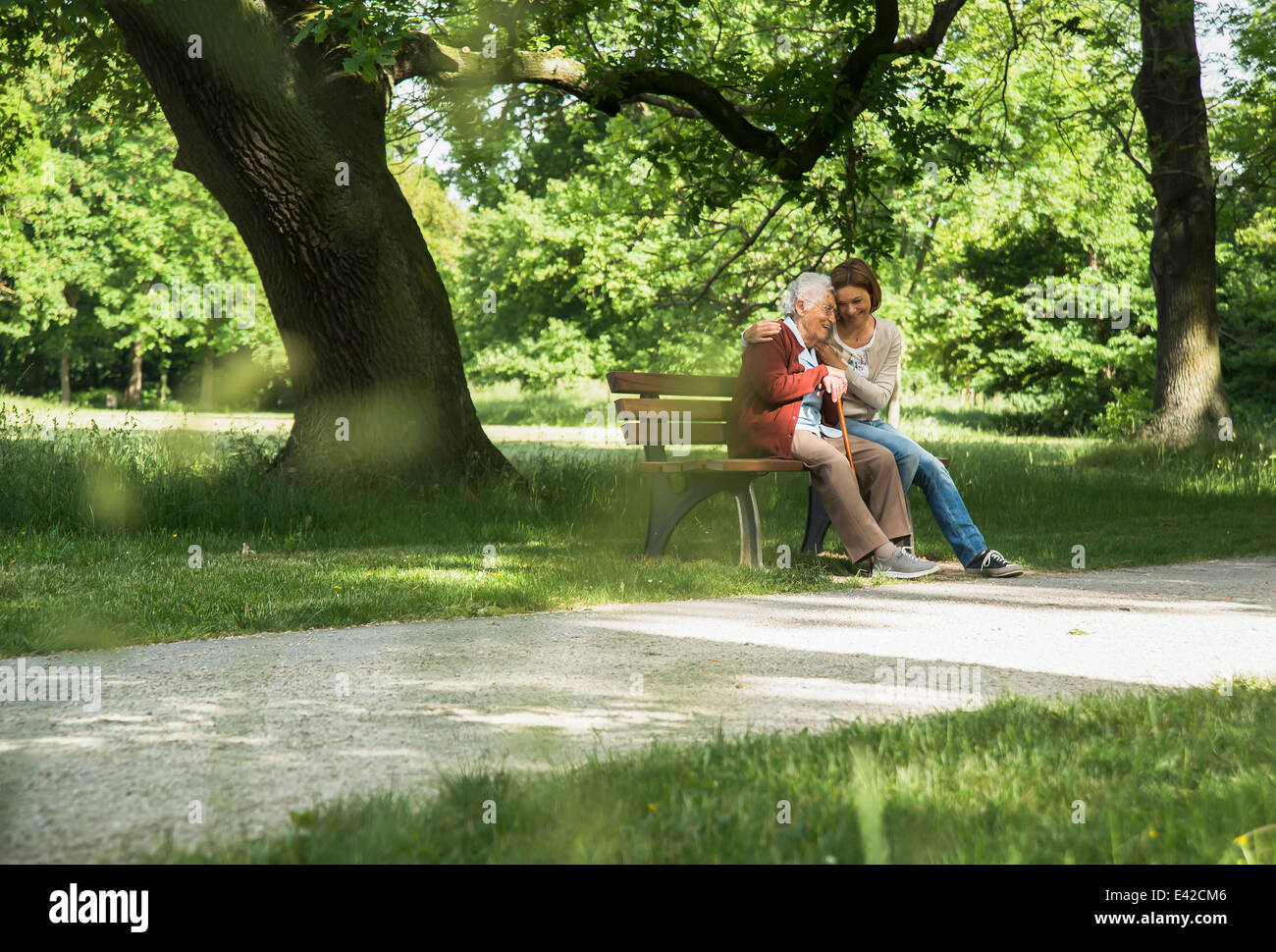 Senior donna seduta su una panchina nel parco con il nipote Foto Stock