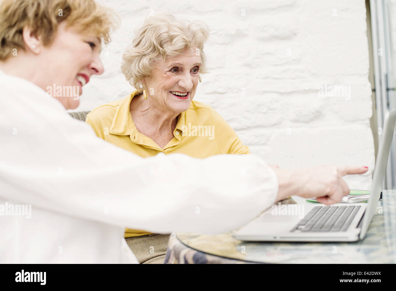 Donna Senior e figlia guardando al laptop Foto Stock
