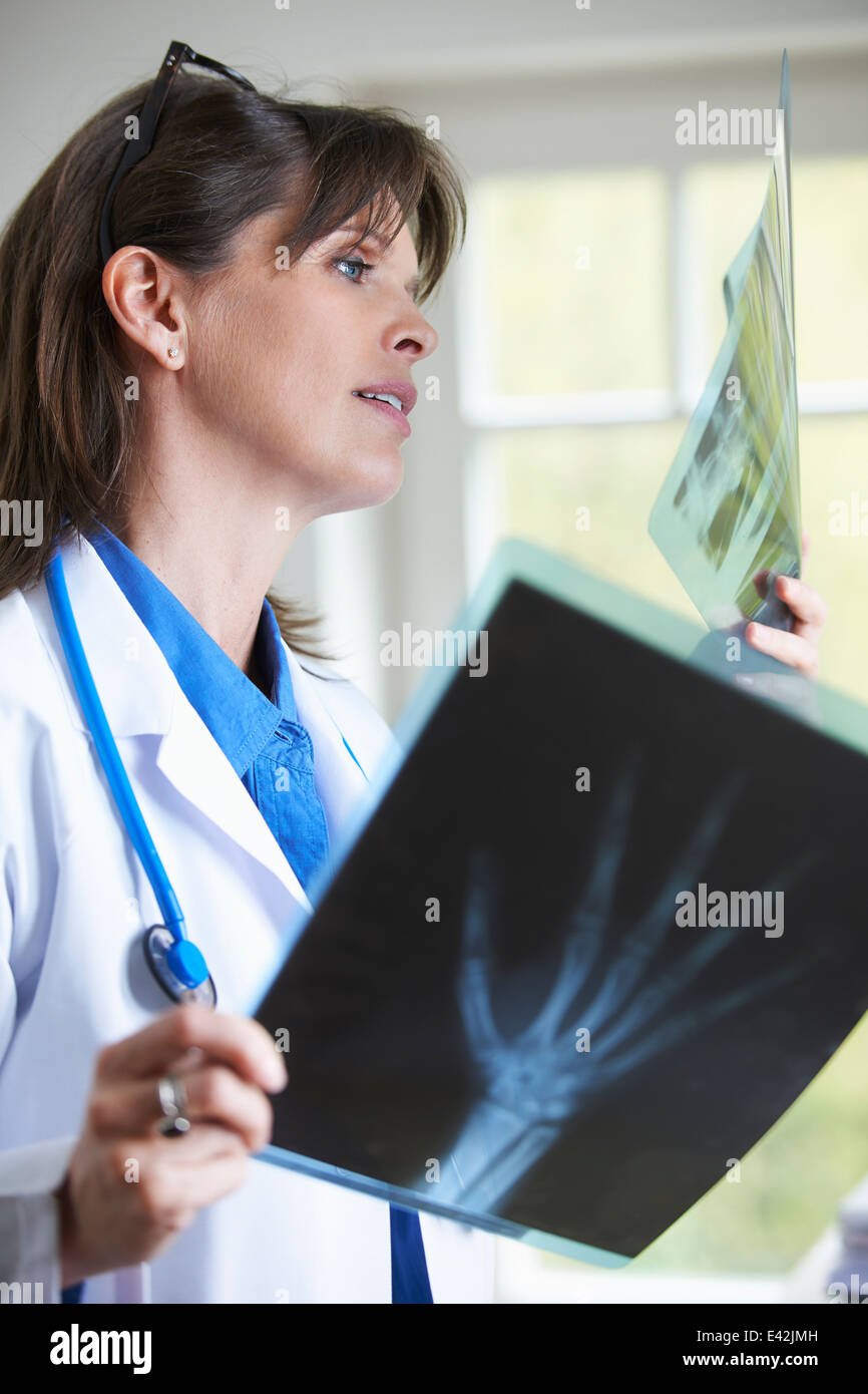 Medico guardando xray immagine della mano Foto Stock