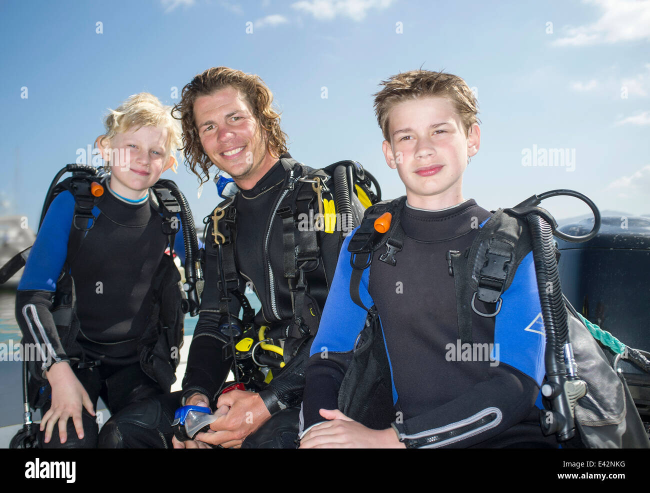 Ritratto di due ragazzi con metà maschio adulto scuba diving insegnante Foto Stock