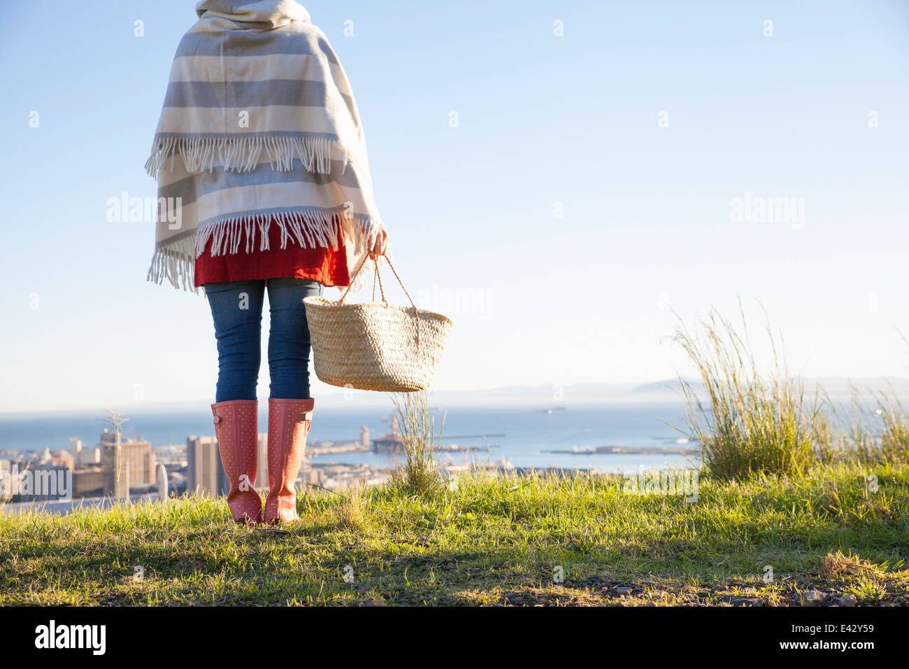 Vista posteriore del giovane donna sulla collina con vista sul mare Foto Stock