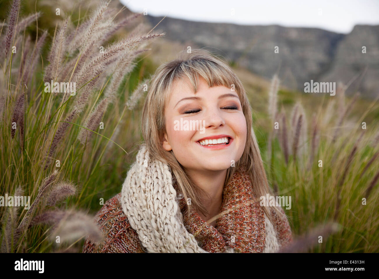 Ritratto di giovane donna tra erba lunga con gli occhi chiusi Foto Stock