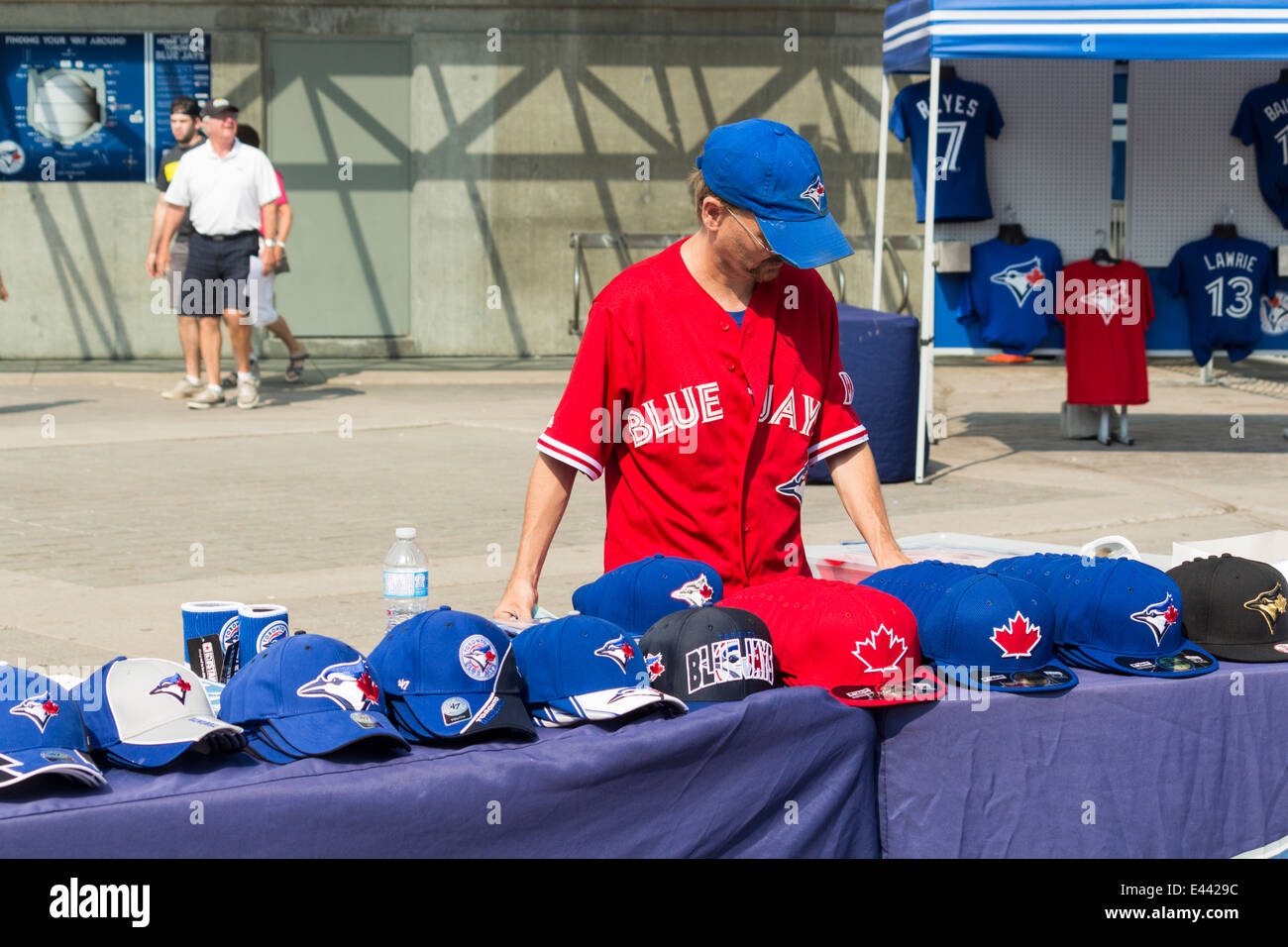 Fornitore maschio in rosso Blue Jays Jersey il Canada day weekend vendita di Toronto Blue Jays cappelli e maglioni fuori il Rogers Centre Foto Stock