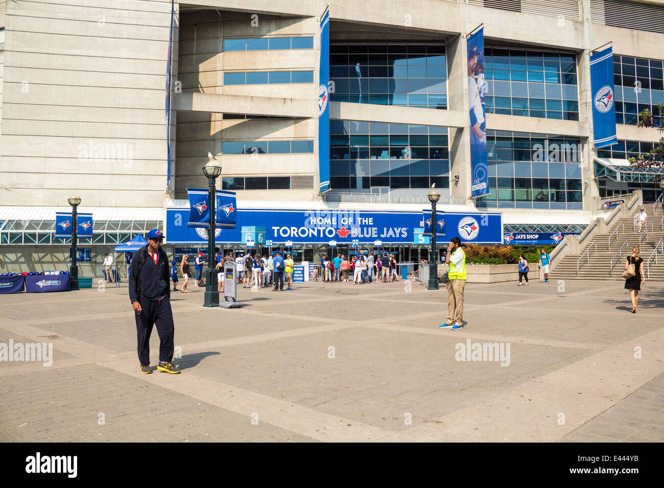 La gente camminare intorno al di fuori del Rogers Centre prima a Toronto Blue Jay baseball gioco su una soleggiata giornata estiva Foto Stock