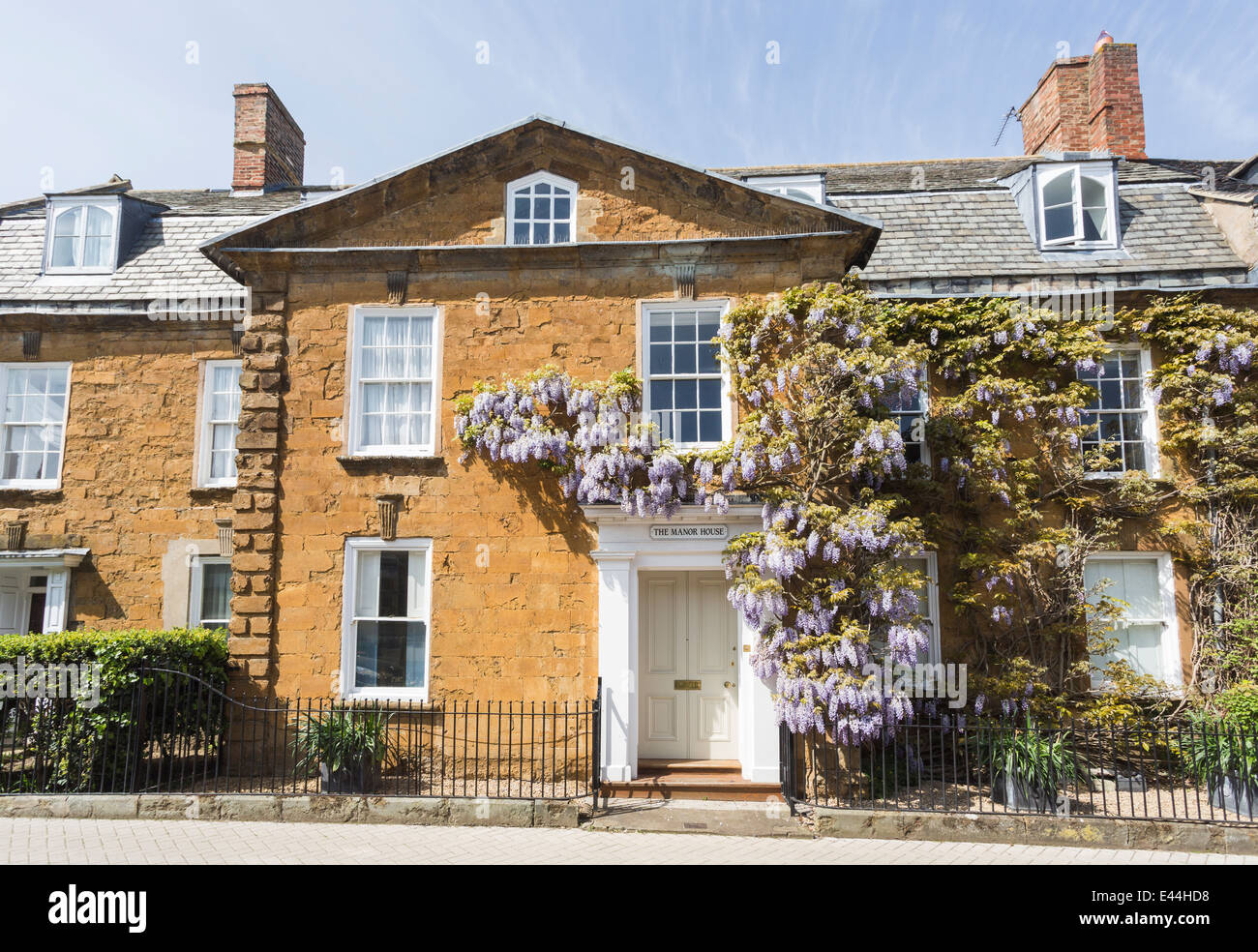 Tradizionale Cotswold stone town house a Shipston on Stour, Warwickshire, con viola glicine round crescente della porta anteriore Foto Stock