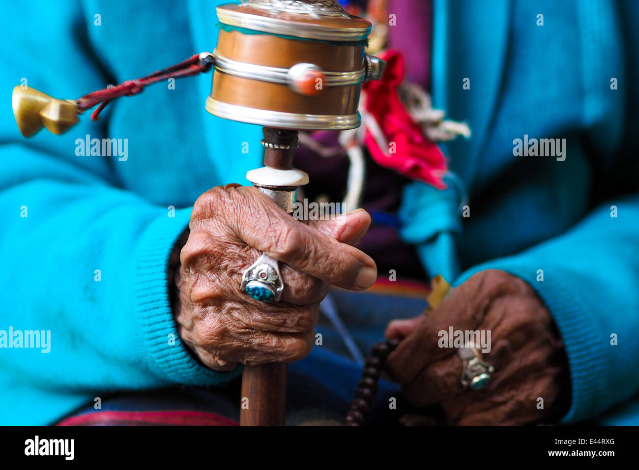 La rotazione la preghiera buddista ruota alla vecchia donna della mano, del Nepal Foto Stock
