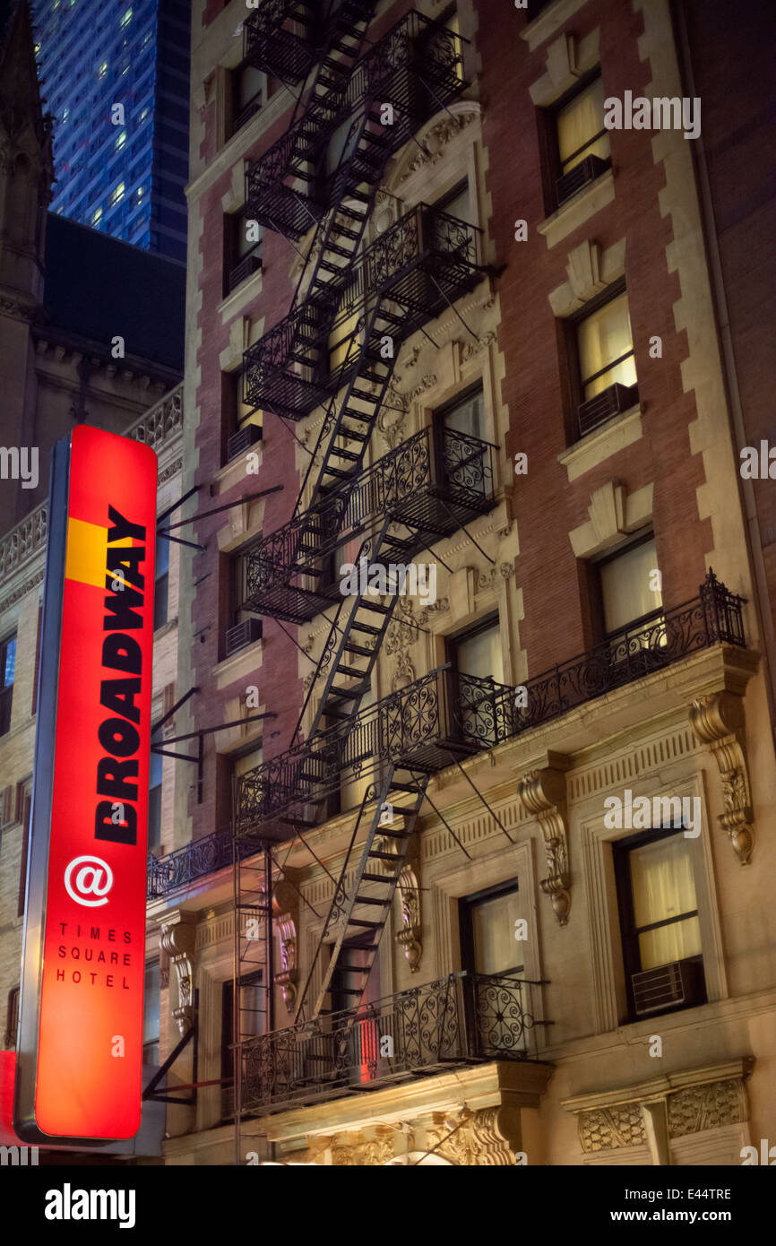 Edificio con illuminato in rosso segno e fire sfugge su Broadway, Manhattan, New York City. Foto Stock