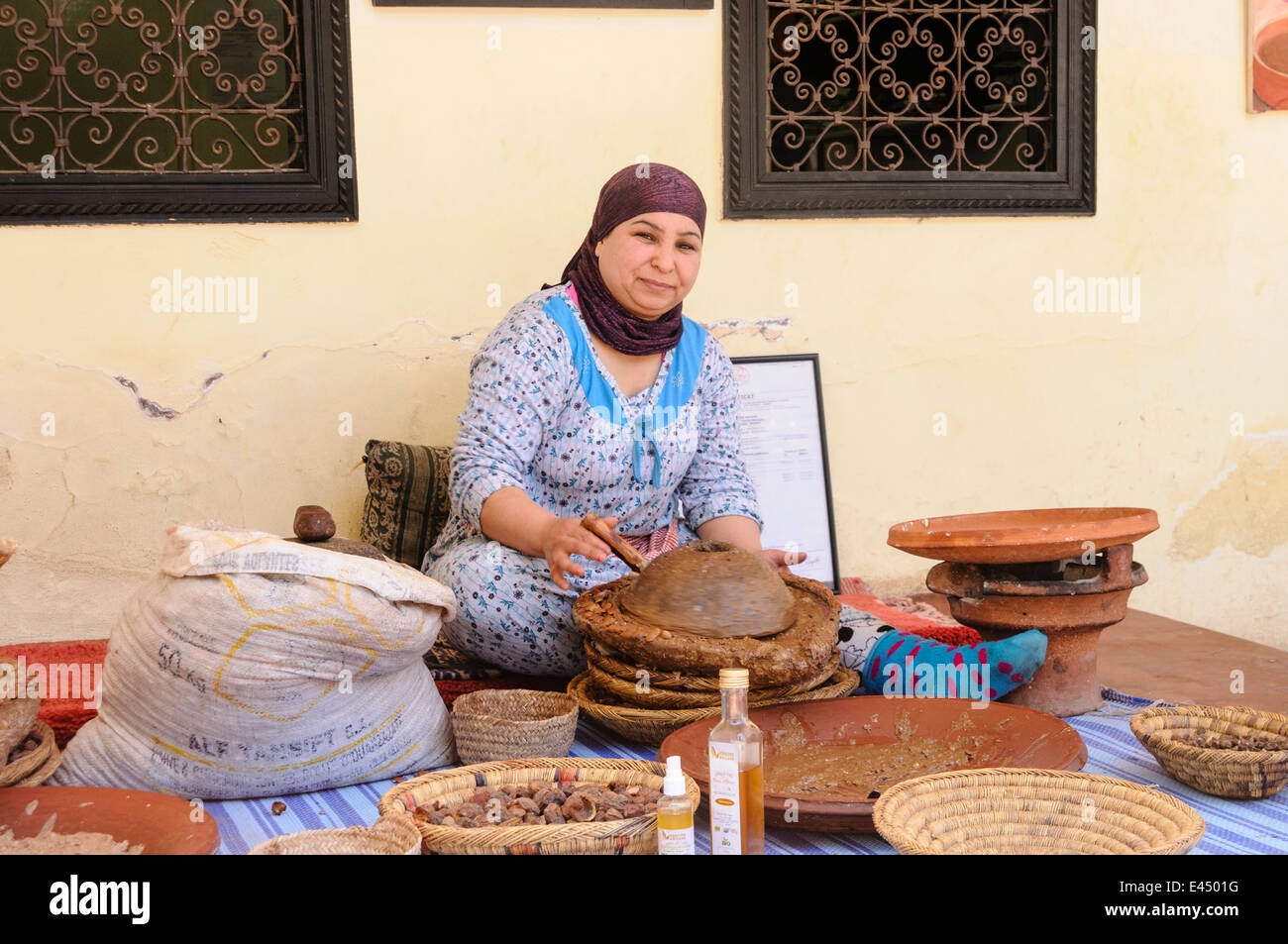 Una donna marocchina macina i dadi di Argan fino Atlas Mountains, Marocco Foto Stock