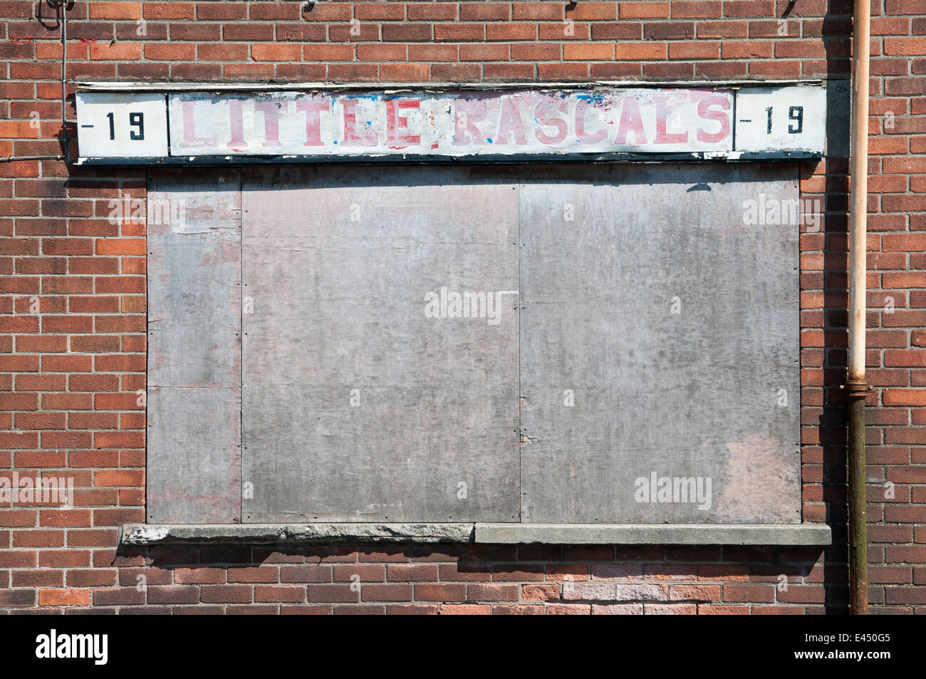 Abbandonata e intavolato negozio 'Little Rascals' che una volta venduto l'abbigliamento infantile Foto Stock