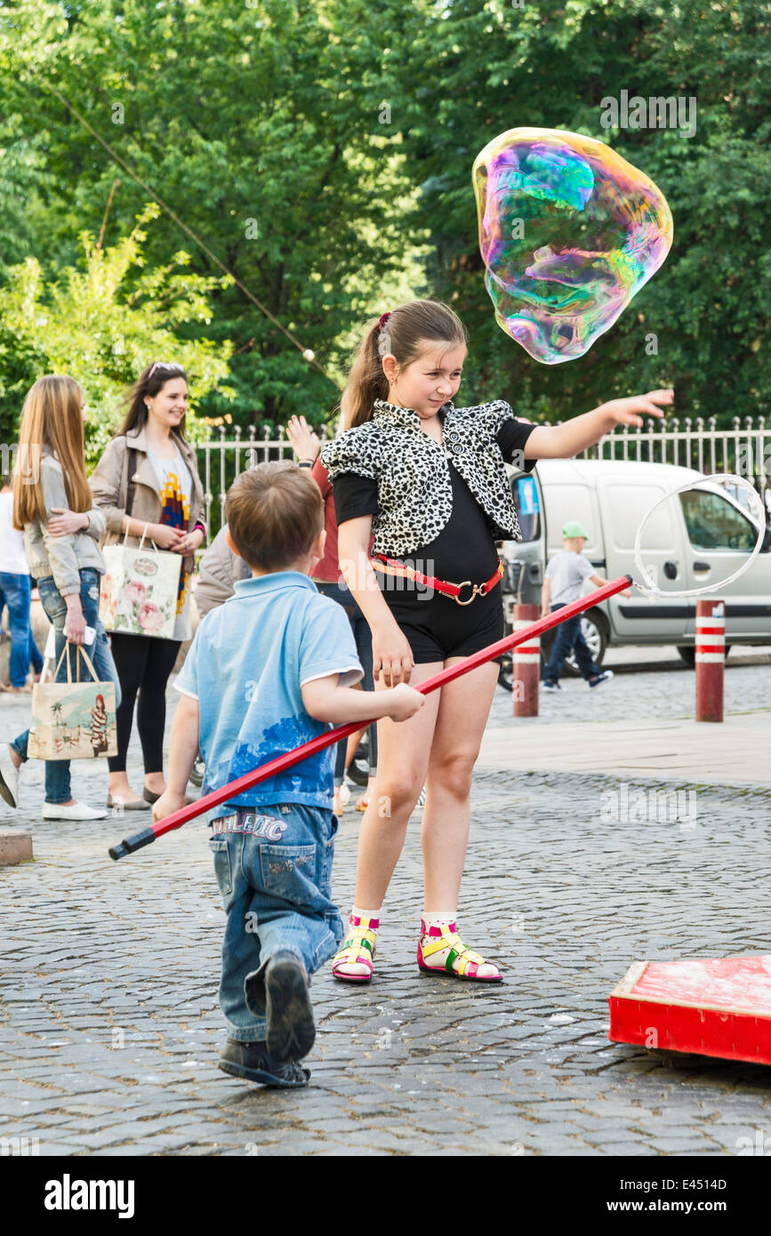 Ragazzo giovane soffiare bolle a Olha Kobylianska Street zona pedonale in Chernivtsi, Bukovina Regione, Ucraina Foto Stock