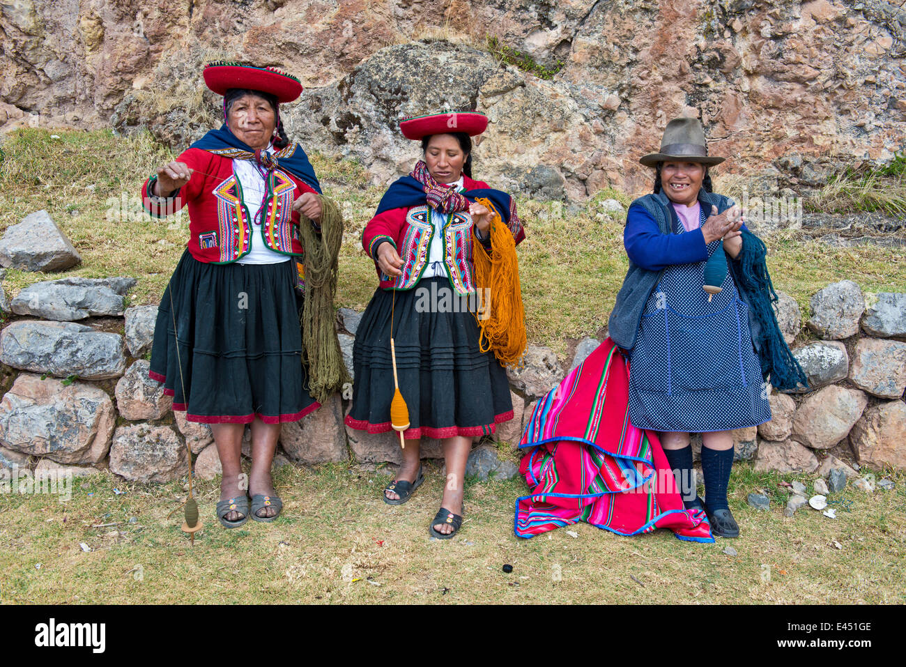 Tre donne anziane indossare cappelli, gli Indiani Quechua in abito tradizionale la filatura della lana di legno di mandrini, Cinchero Foto Stock
