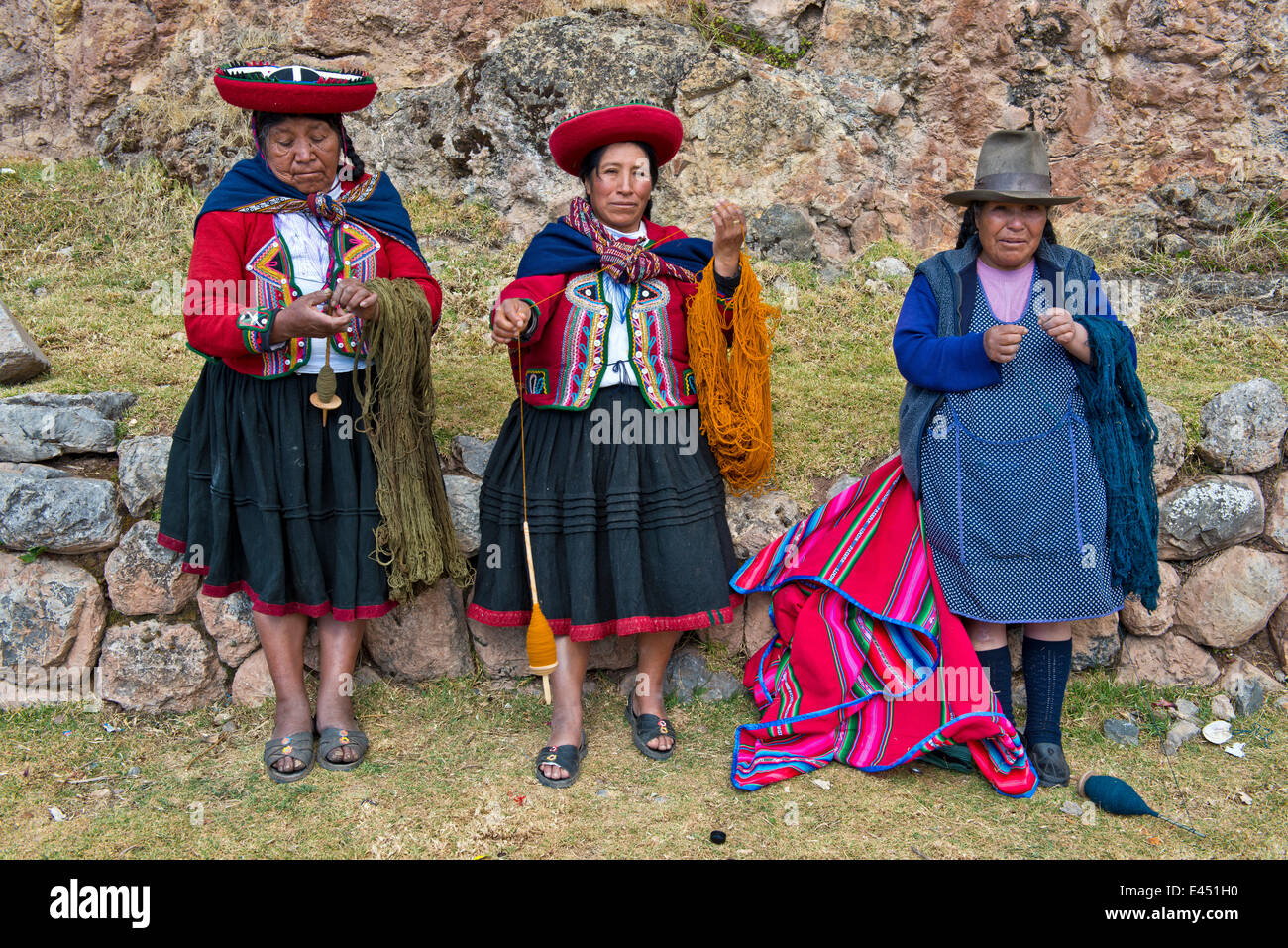 Tre donne anziane indossare cappelli, gli Indiani Quechua in abito tradizionale la filatura della lana di legno di mandrini, Cinchero Foto Stock