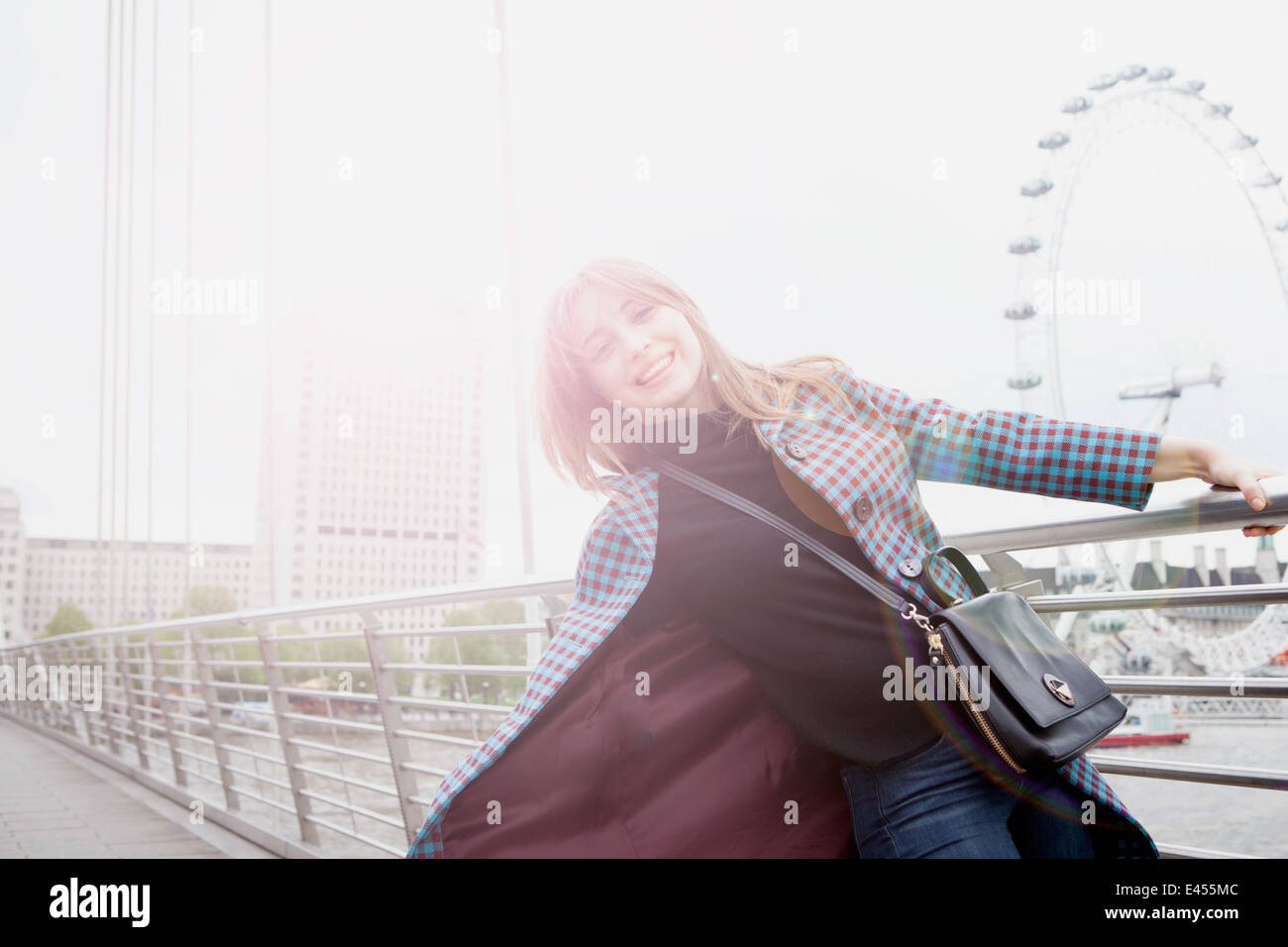 Ritratto di giovane turista femminile basculante in Golden Jubilee passerella, London, Regno Unito Foto Stock