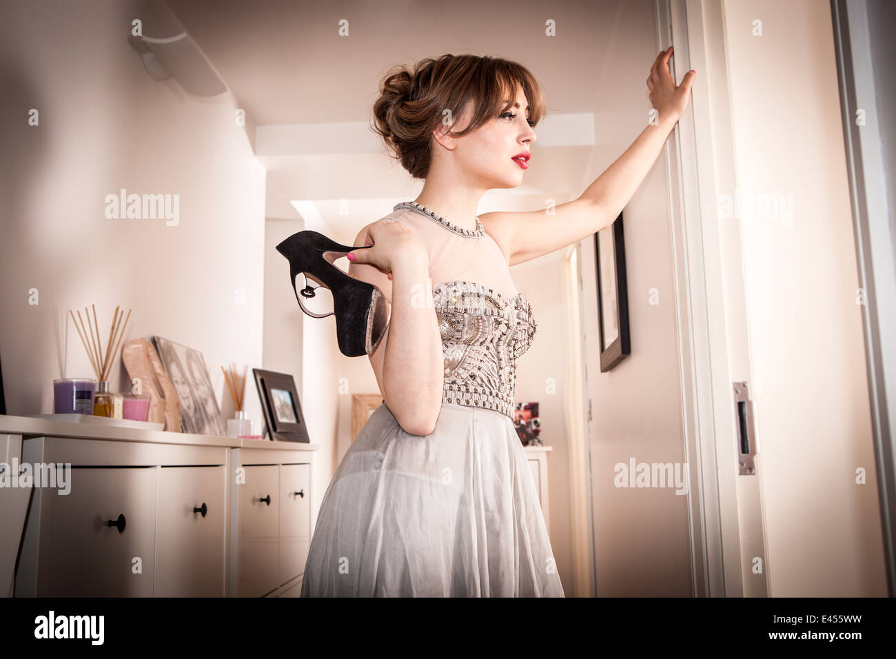 Stanco giovane donna in abito da sera in corridoio Foto Stock