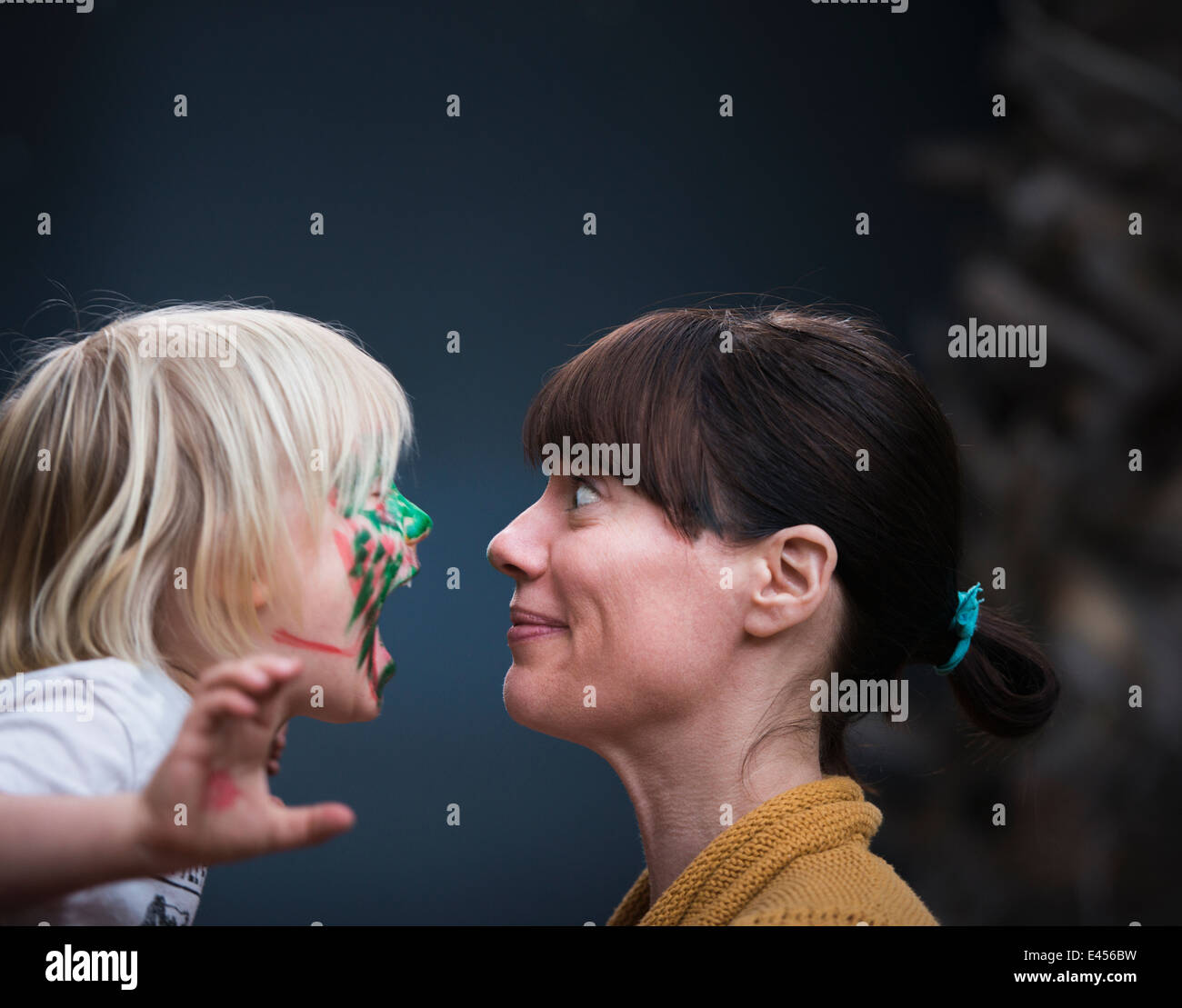Faccia a faccia ritratto di madri sorpresa per giovani figli faccia dipinta Foto Stock
