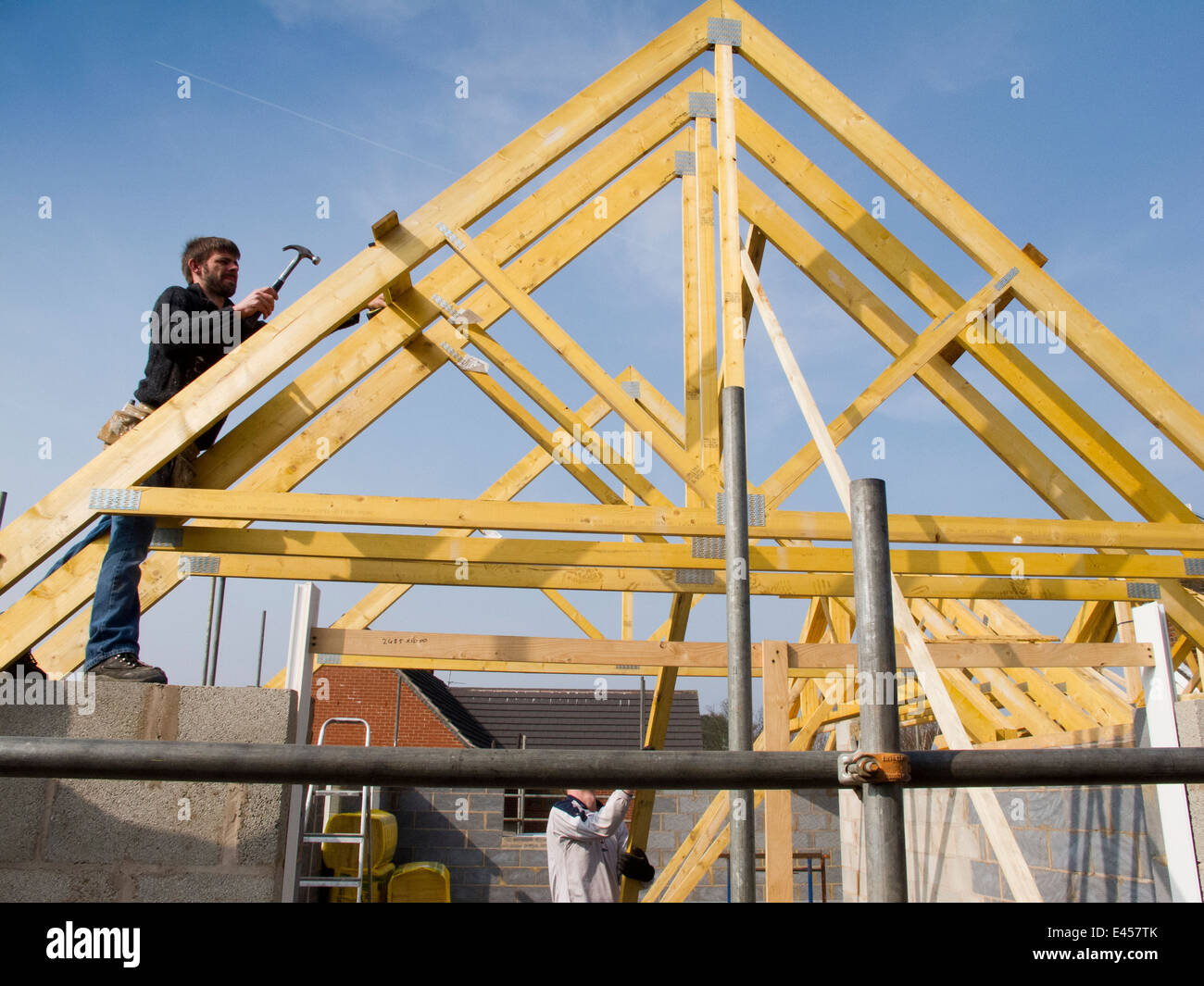 Auto casa Costruzione, costruzione tetto, falegname che fissa il tetto a capriate in posizione Foto Stock