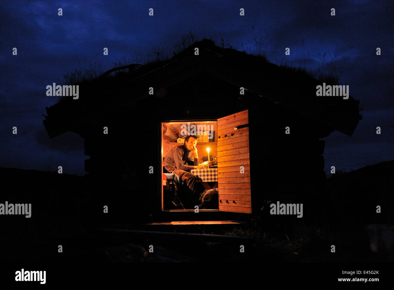 Fotografo, Vincent Munier, seduta in piccolo tradizionale cabina con un tetto di erba, di notte, Forollhogna National Park, Norvegia, sulla posizione per meraviglie selvatiche di Europa, Settembre 2008 Foto Stock