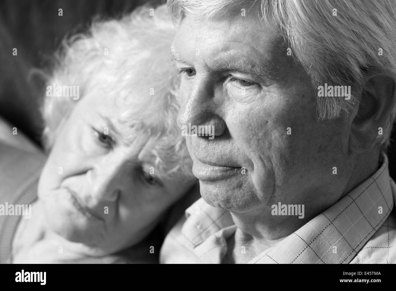 Un ritratto in bianco e nero di una coppia senior rilassante all'interno. Foto Stock