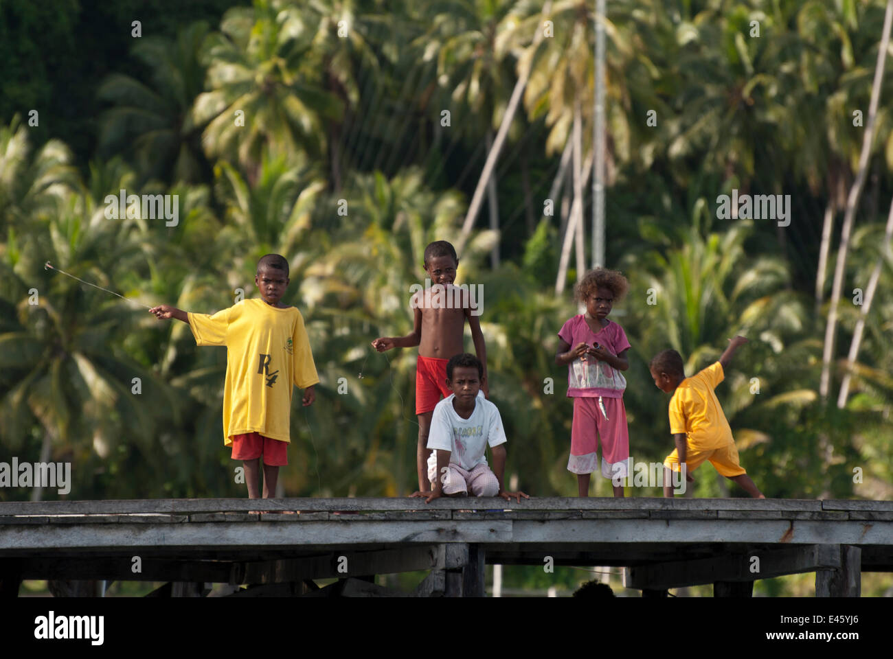 Giovani Papua Occidentale i bambini la pesca dal loro villaggio jetty. Raja Ampat, Papua occidentale, in Indonesia, Febbraio 2010 Foto Stock