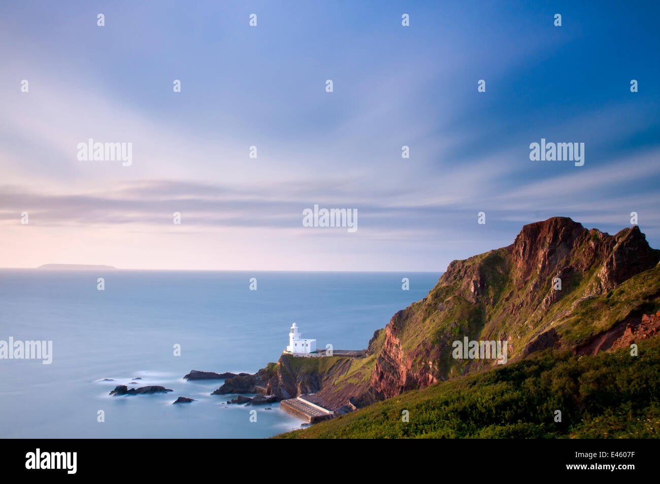 Hartland faro, nr Hartland Point, nella tarda sera luce , con una vista a Lundy Island. North Devon, Regno Unito, Agosto 2010 Foto Stock