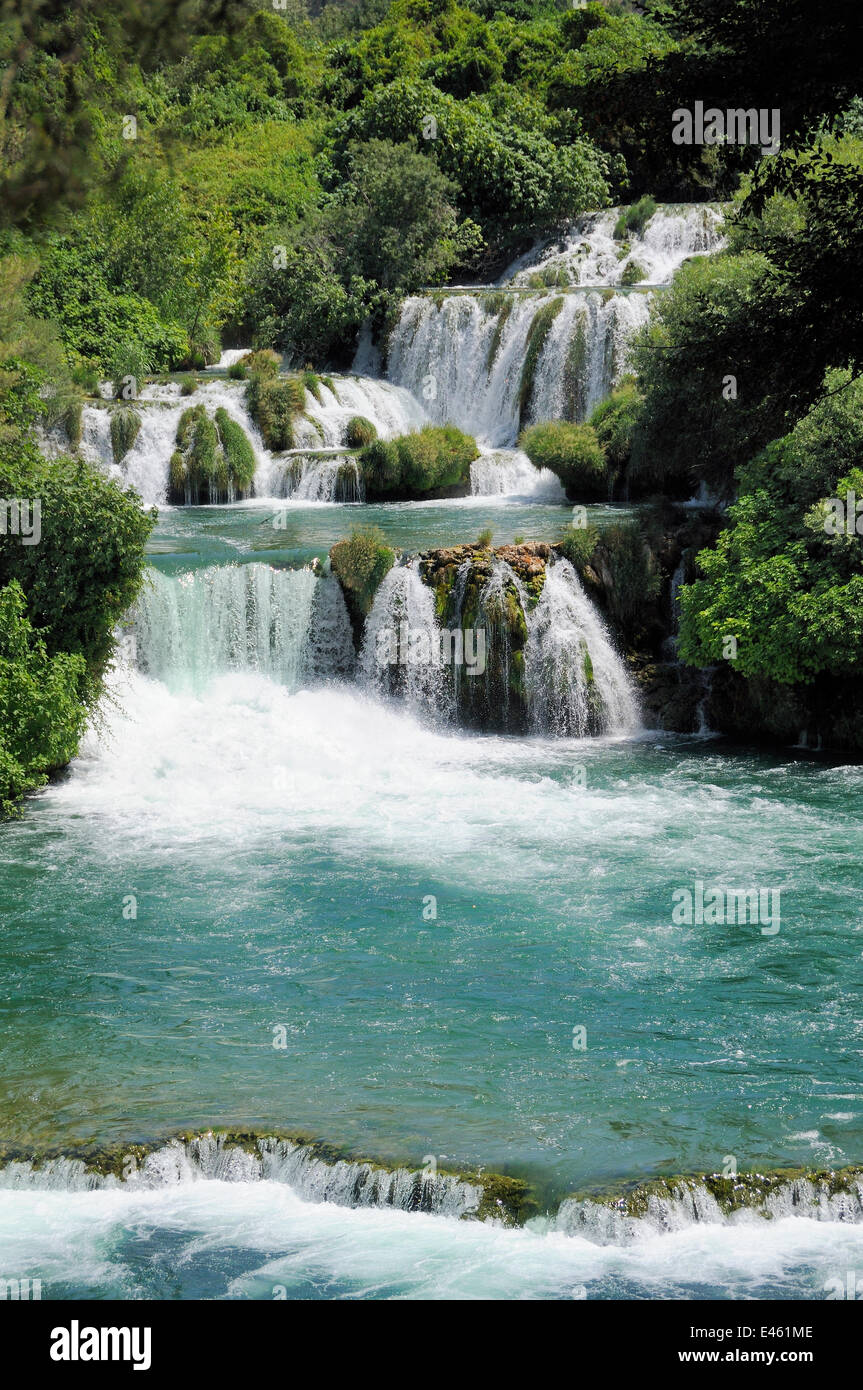 Fiume Krka scorre su una serie di dighe in travertino o barriere di Skradinski buk cascate, con fitte foreste circonda, Parco Nazionale di Krka, Sibenik, Croazia, luglio 2010. Foto Stock