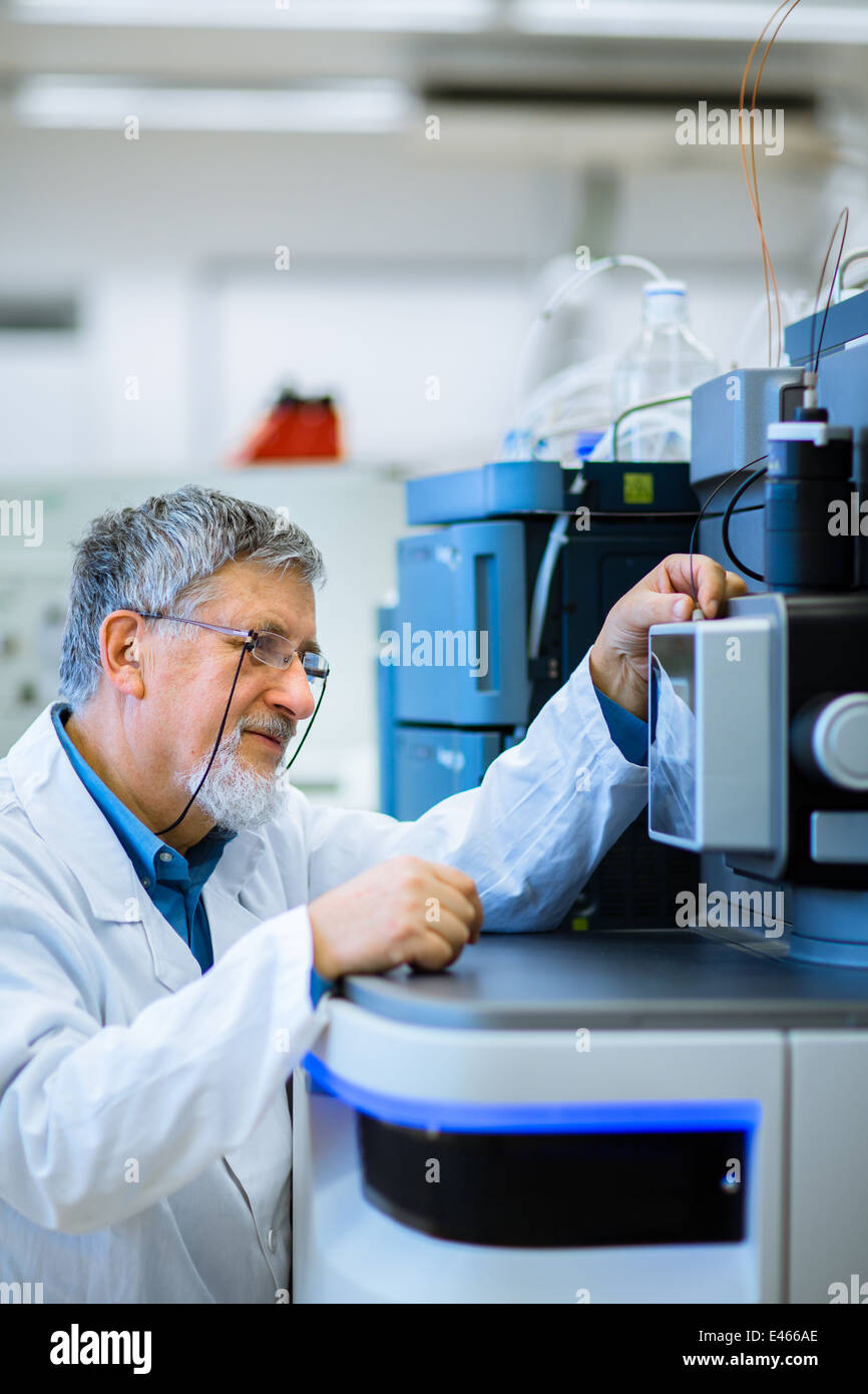Maschio senior researcher di effettuare attività di ricerca scientifica in un laboratorio (SHALLOW DOF; dai toni di colore immagine) Foto Stock