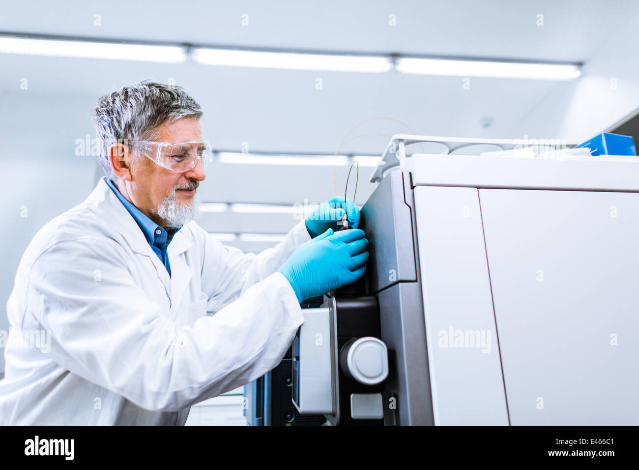 Maschio senior researcher di effettuare attività di ricerca scientifica in un laboratorio (SHALLOW DOF; dai toni di colore immagine) Foto Stock