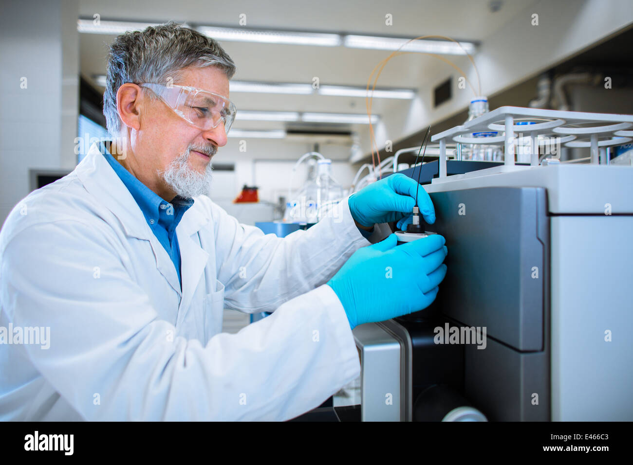 Maschio senior researcher di effettuare attività di ricerca scientifica in un laboratorio (SHALLOW DOF; dai toni di colore immagine) Foto Stock