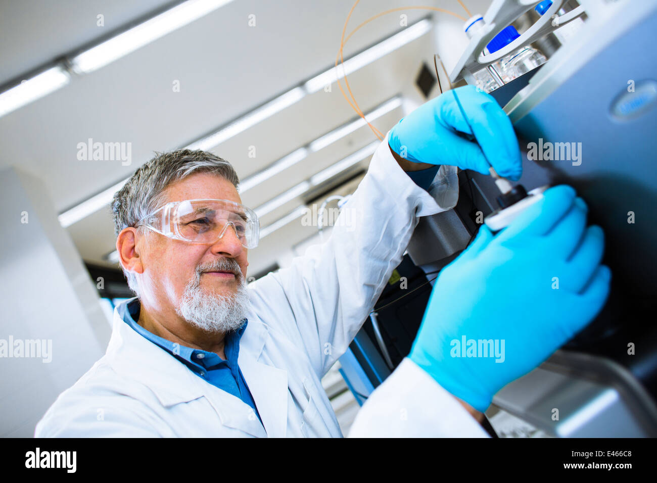 Maschio senior researcher di effettuare attività di ricerca scientifica in un laboratorio (SHALLOW DOF; dai toni di colore immagine) Foto Stock