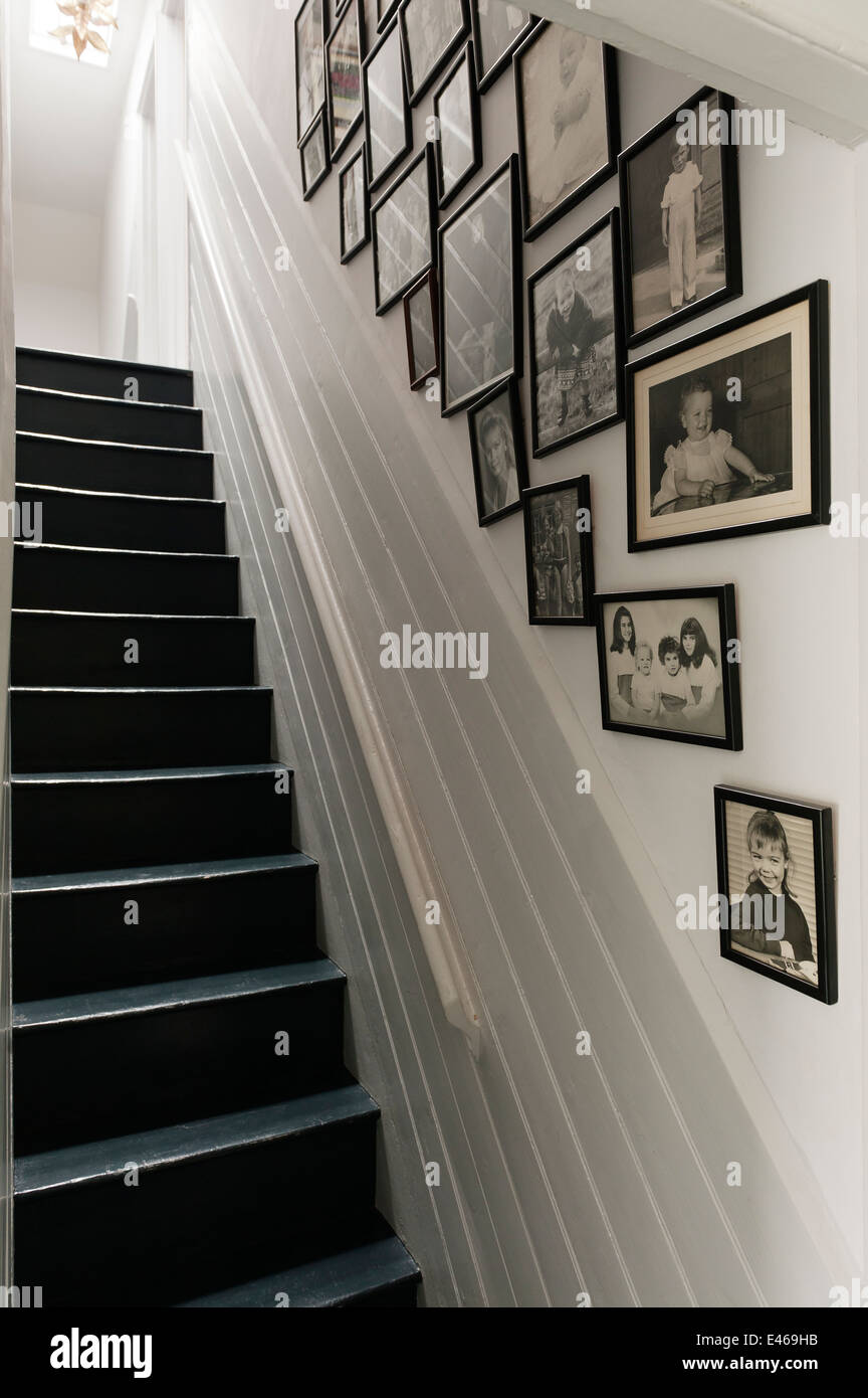 Cornice foto in bianco e nero sulla parete lungo la scala Foto Stock