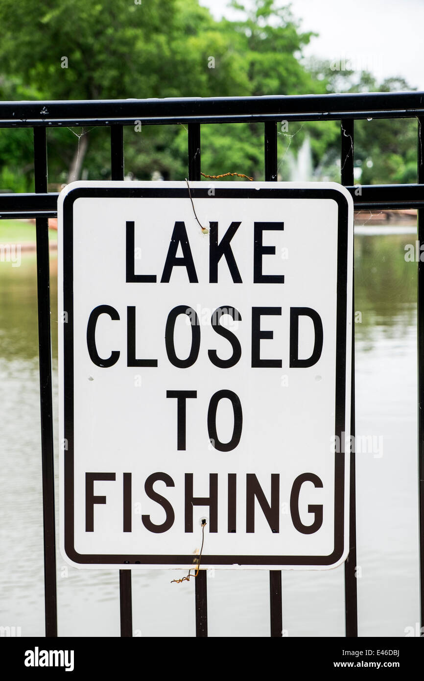 Un segno di informare il lago di Chiusi per la pesca è pubblicato su una rampa di recinto vicino a un piccolo lago in un parco pubblico nella città di Oklahoma, Oklahoma, Stati Uniti d'America. Foto Stock