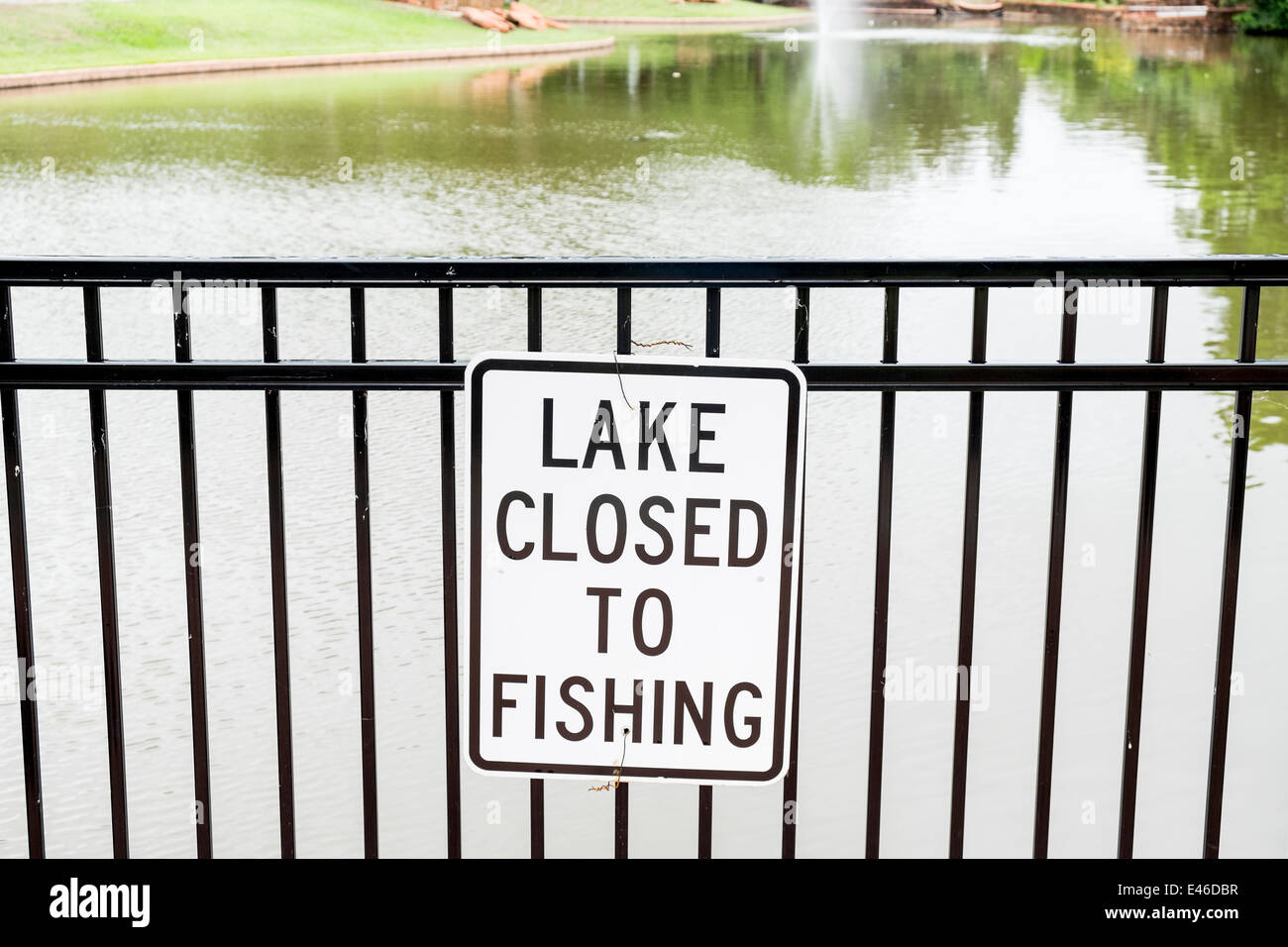 Un segno di informare il lago di Chiusi per la pesca è pubblicato su una rampa di recinto vicino a un piccolo lago in un parco pubblico nella città di Oklahoma, Oklahoma, Stati Uniti d'America. Foto Stock