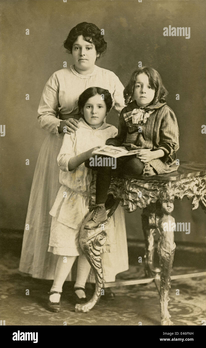Fotografia di antiquariato, circa 1910 studio immagine di una madre e le sue due figlie, uno con un libro in mano. Foto Stock
