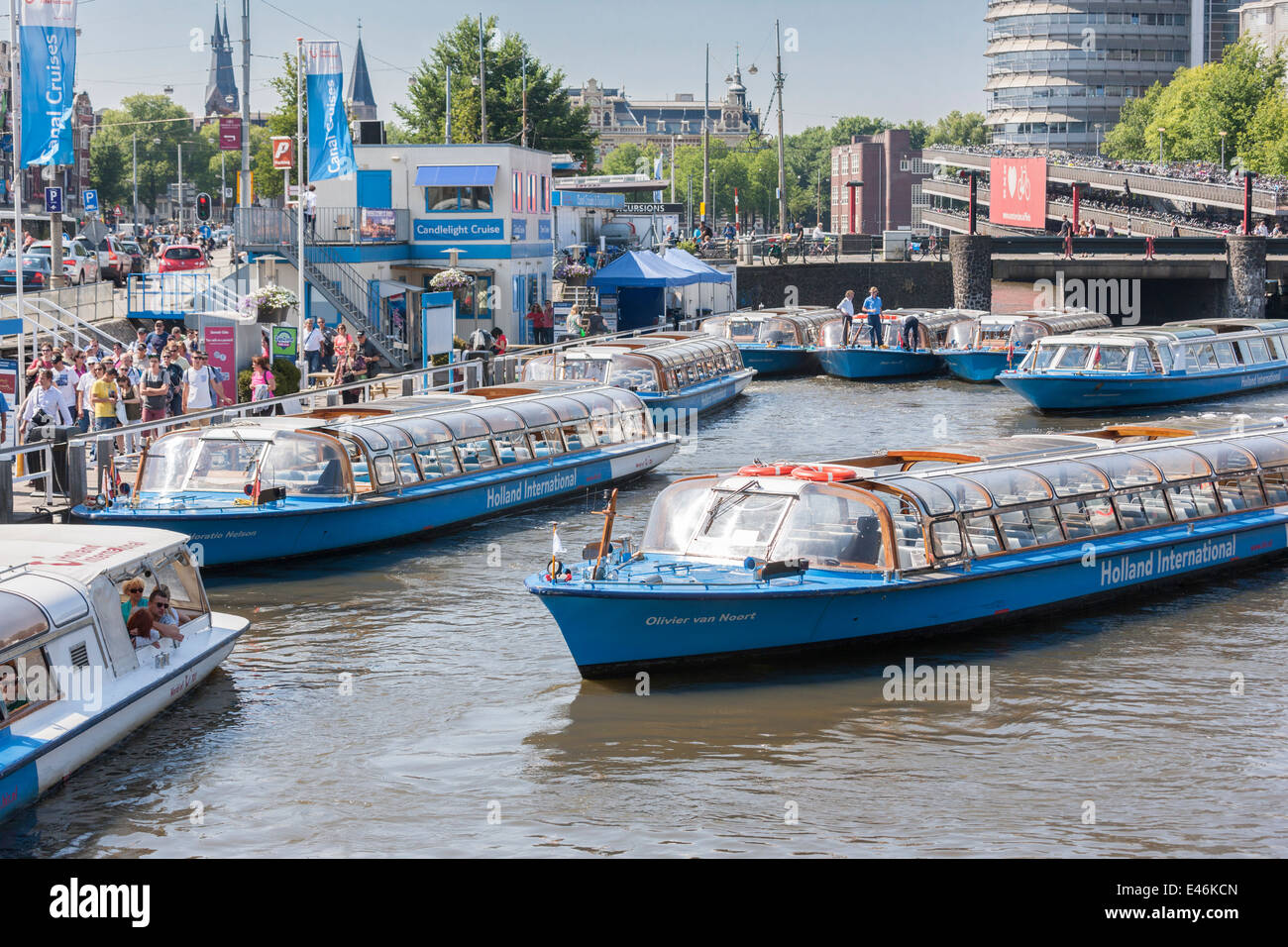 La Stazione Centrale di Amsterdam crociera fodera barche fino a prendere i turisti su un canal tour attraverso canali più famosi del Grachtengordel. Foto Stock