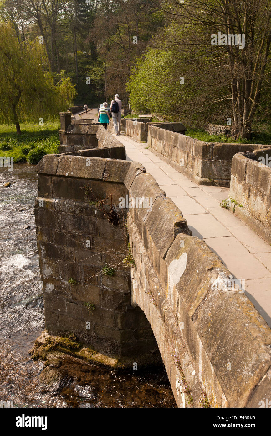 Regno Unito, Derbyshire, Peak District, Bakewell, giovane sul vecchio pack horse ponte sul fiume Wye a Lumford cottages Foto Stock