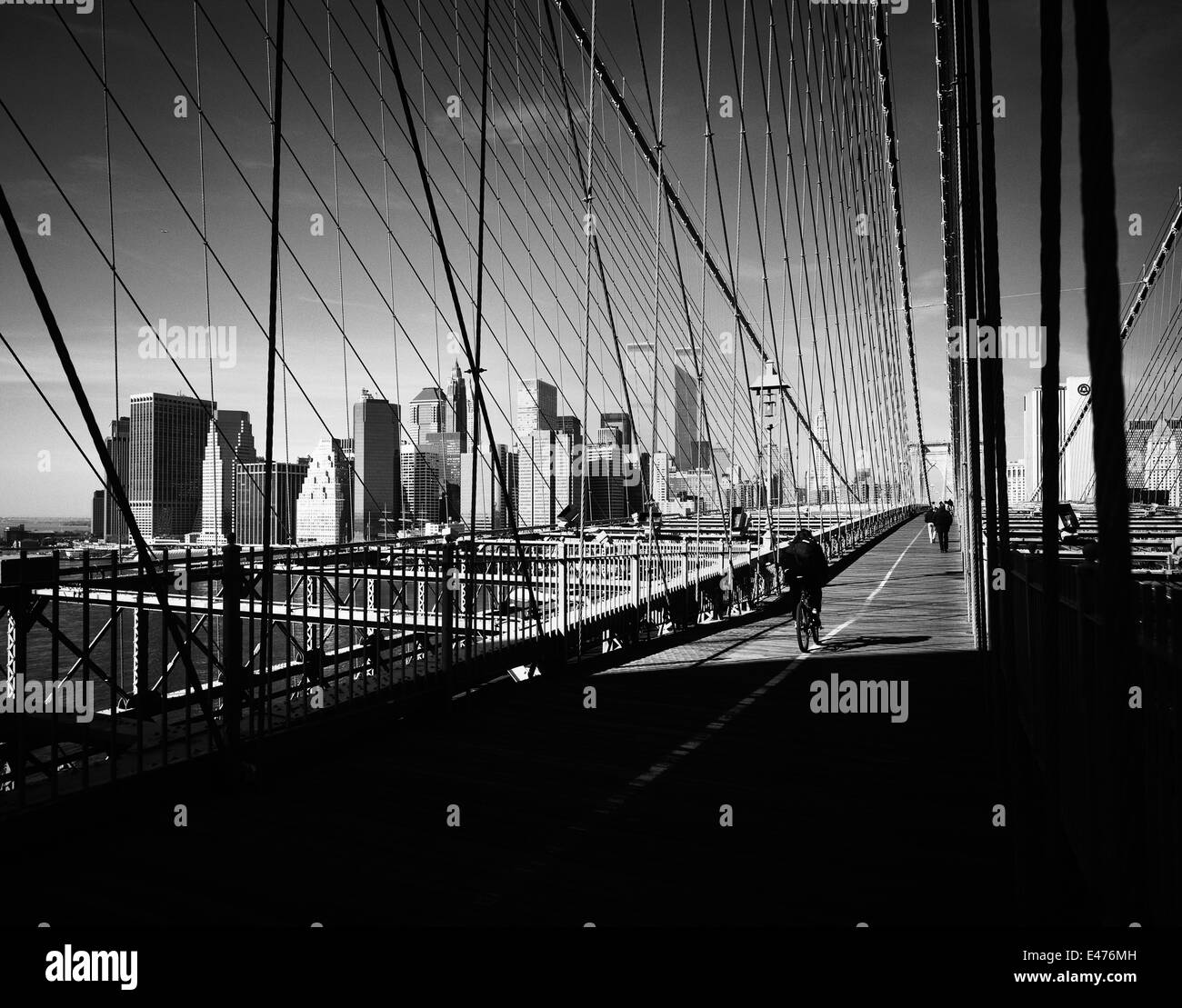 Ciclista sul ponte di Brooklyn e la parte inferiore dello skyline di Manhattan prima dell' 11 settembre 2001 New York City NY USA Foto Stock