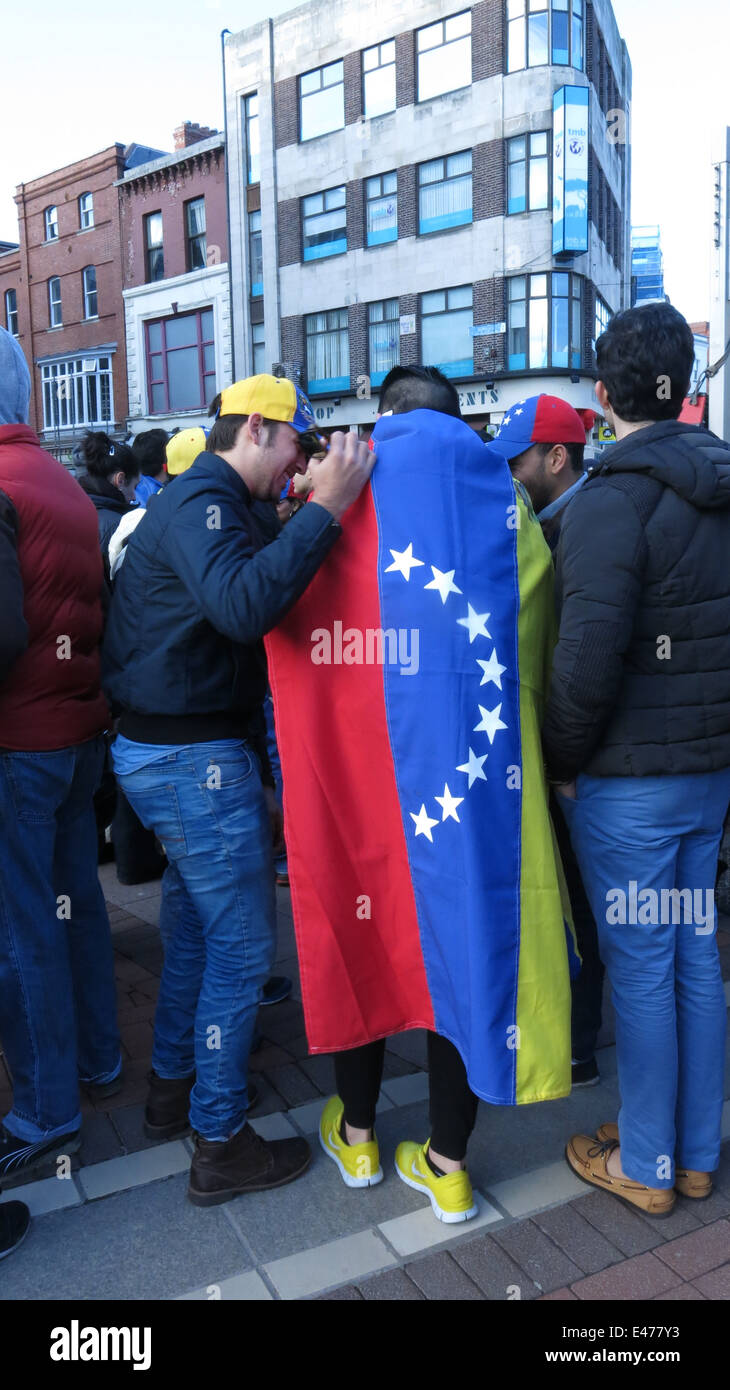 Un uomo che indossa la bandiera venezuelana un capo durante una manifestazione di protesta su Dublino Grafton Street contro il governo del Venezuela. Foto Stock